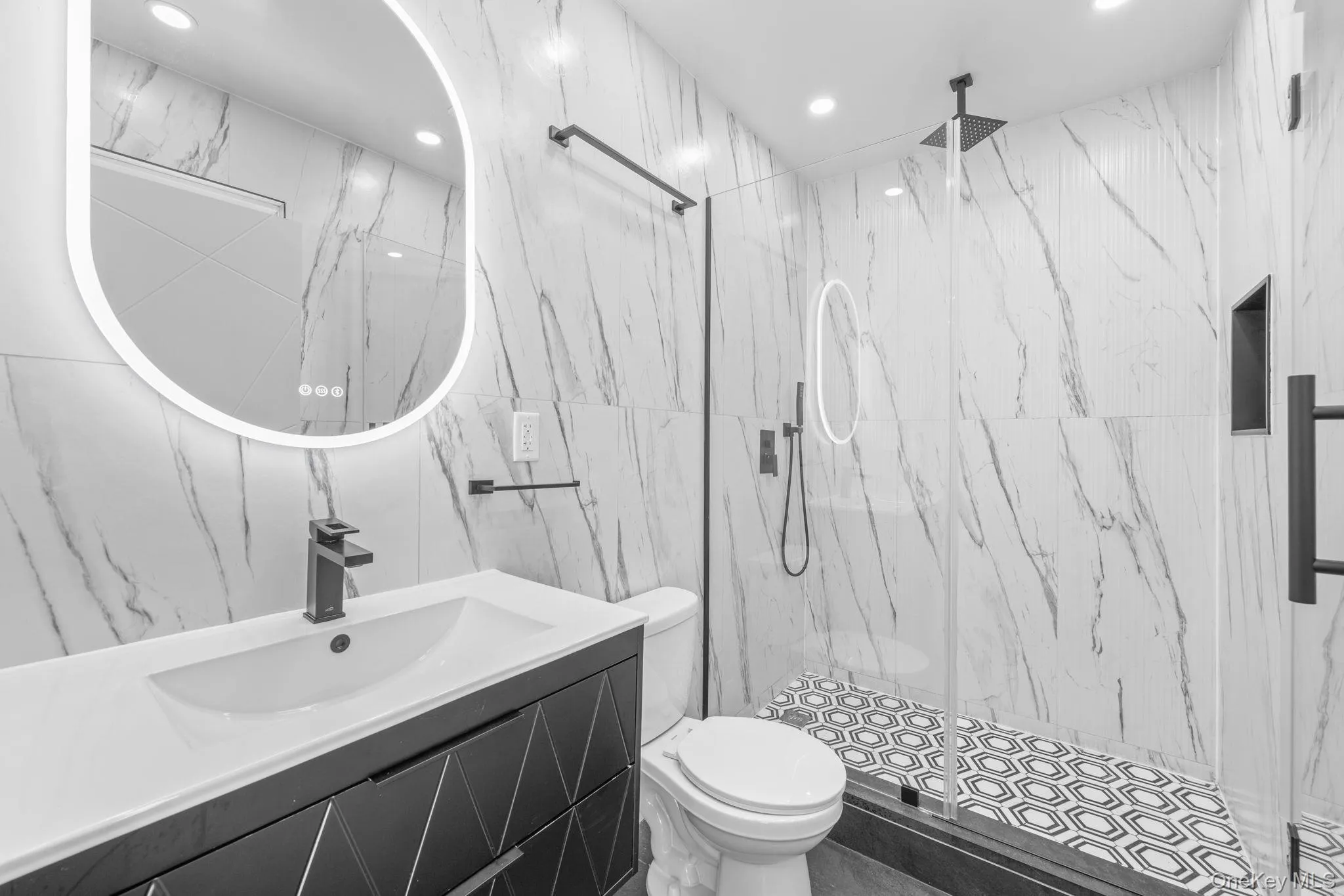 Bathroom with vanity, a marble finish shower, tile walls, and recessed lighting Bathroom with vanity, a marble finish shower, tile walls, and recessed lighting