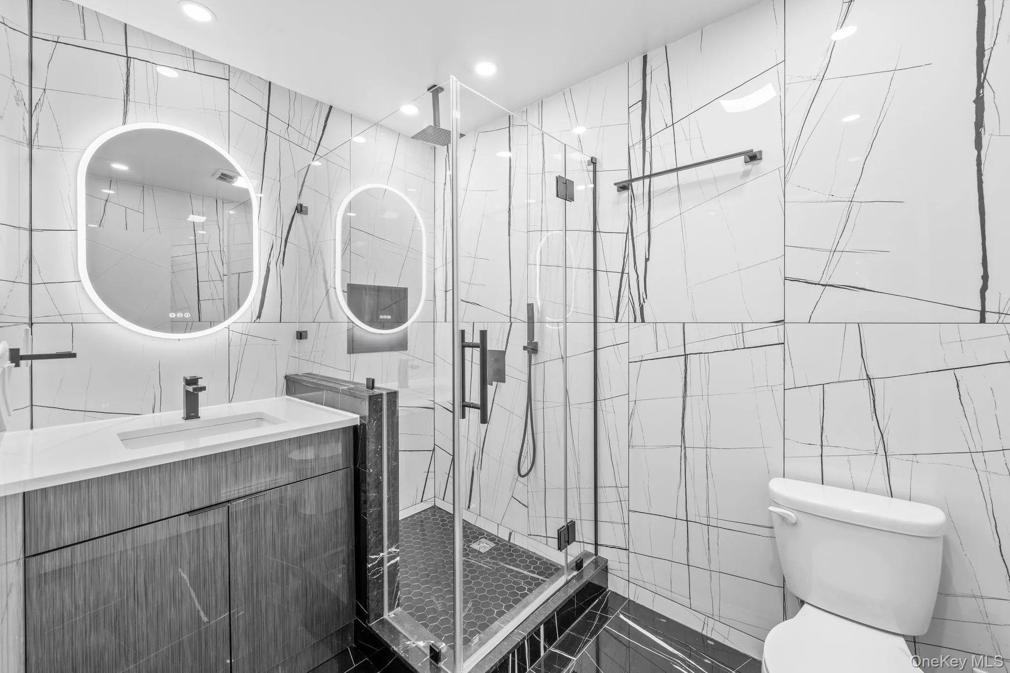 Full bath featuring tile walls, vanity, a stall shower, and recessed lighting Full bath featuring tile walls, vanity, a stall shower, and recessed lighting