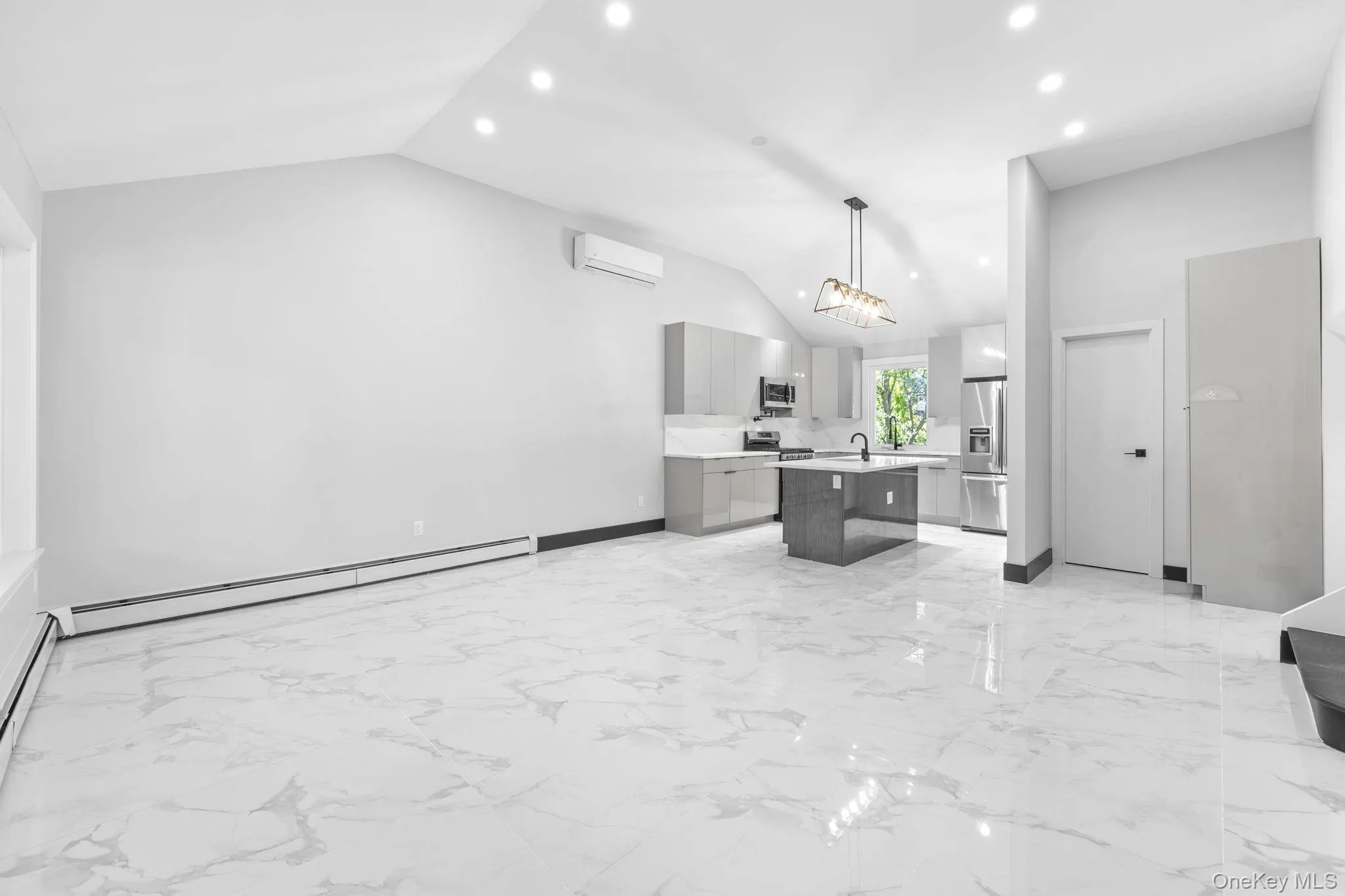Kitchen featuring open floor plan, a center island with sink, light marble finish floors, decorative light fixtures, and recessed lighting Kitchen featuring open floor plan, a center island with sink, light marble finish floors, decorative light fixtures, and recessed lighting