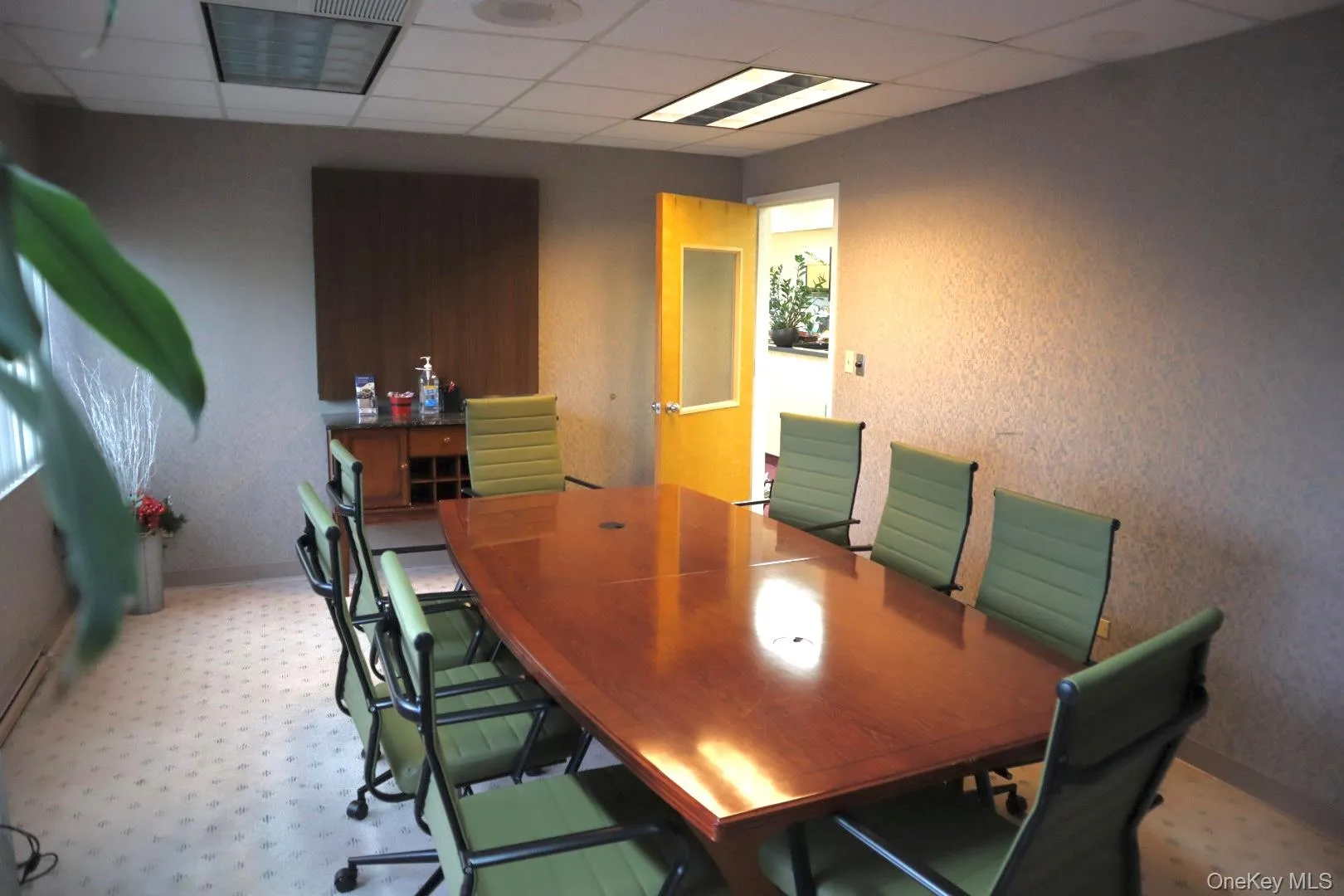 Conference room with a paneled ceiling and a textured wall Conference room with a paneled ceiling and a textured wall
