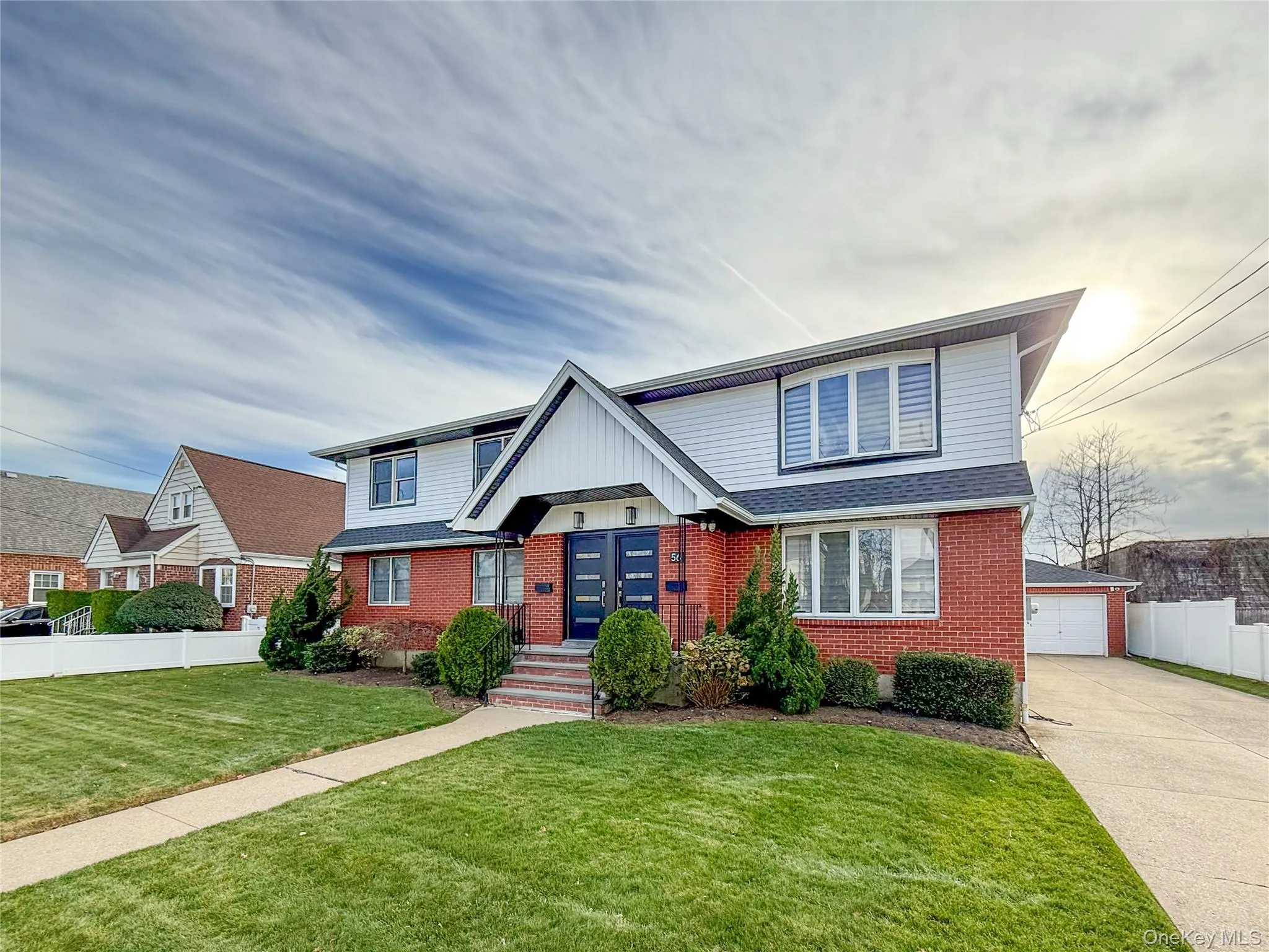 View of front of house with brick siding, an outdoor structure, and a garage View of front of house with brick siding, an outdoor structure, and a garage