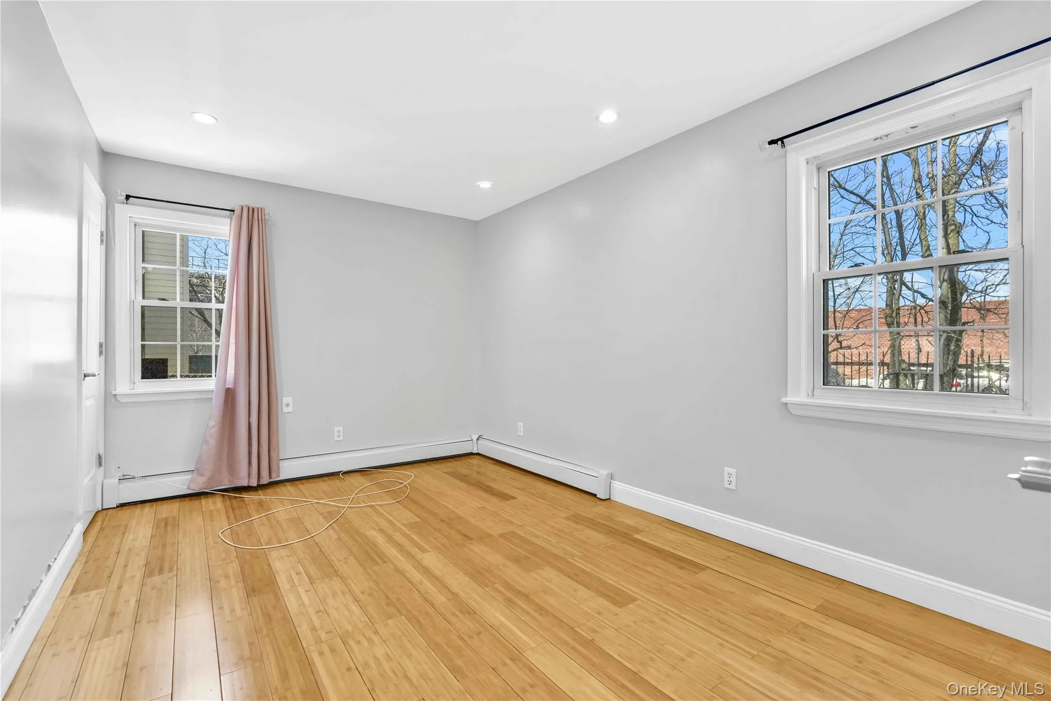 Empty room featuring baseboards, light wood-style flooring, and recessed lighting Empty room featuring baseboards, light wood-style flooring, and recessed lighting
