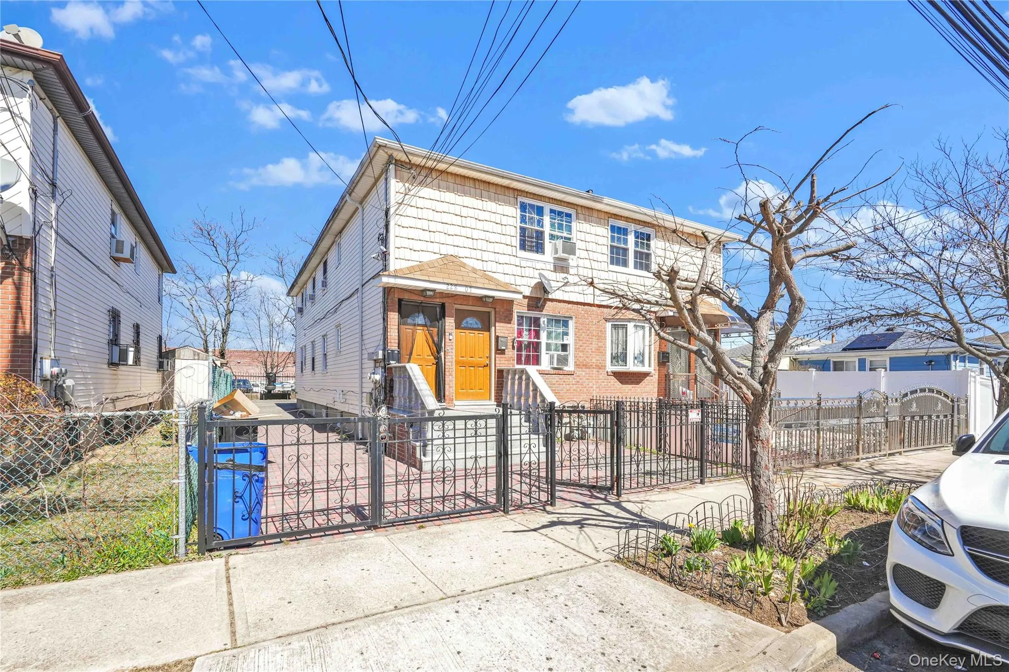 View of front facade with brick siding, a gate, and a fenced front yard View of front facade with brick siding, a gate, and a fenced front yard