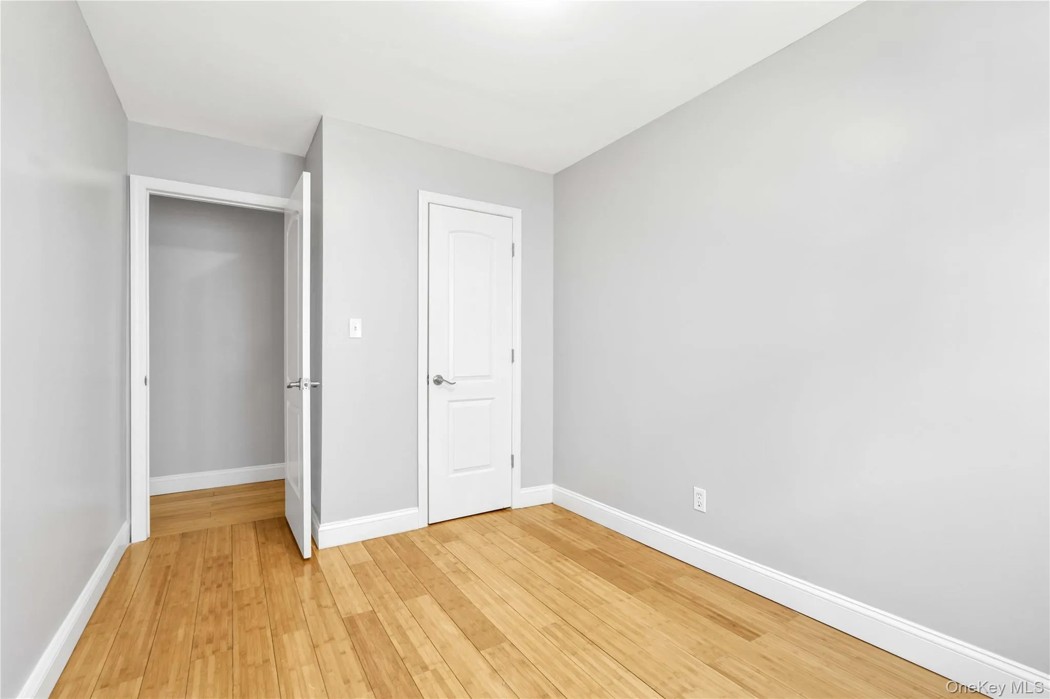 Unfurnished bedroom with light wood-style flooring and baseboards Unfurnished bedroom with light wood-style flooring and baseboards
