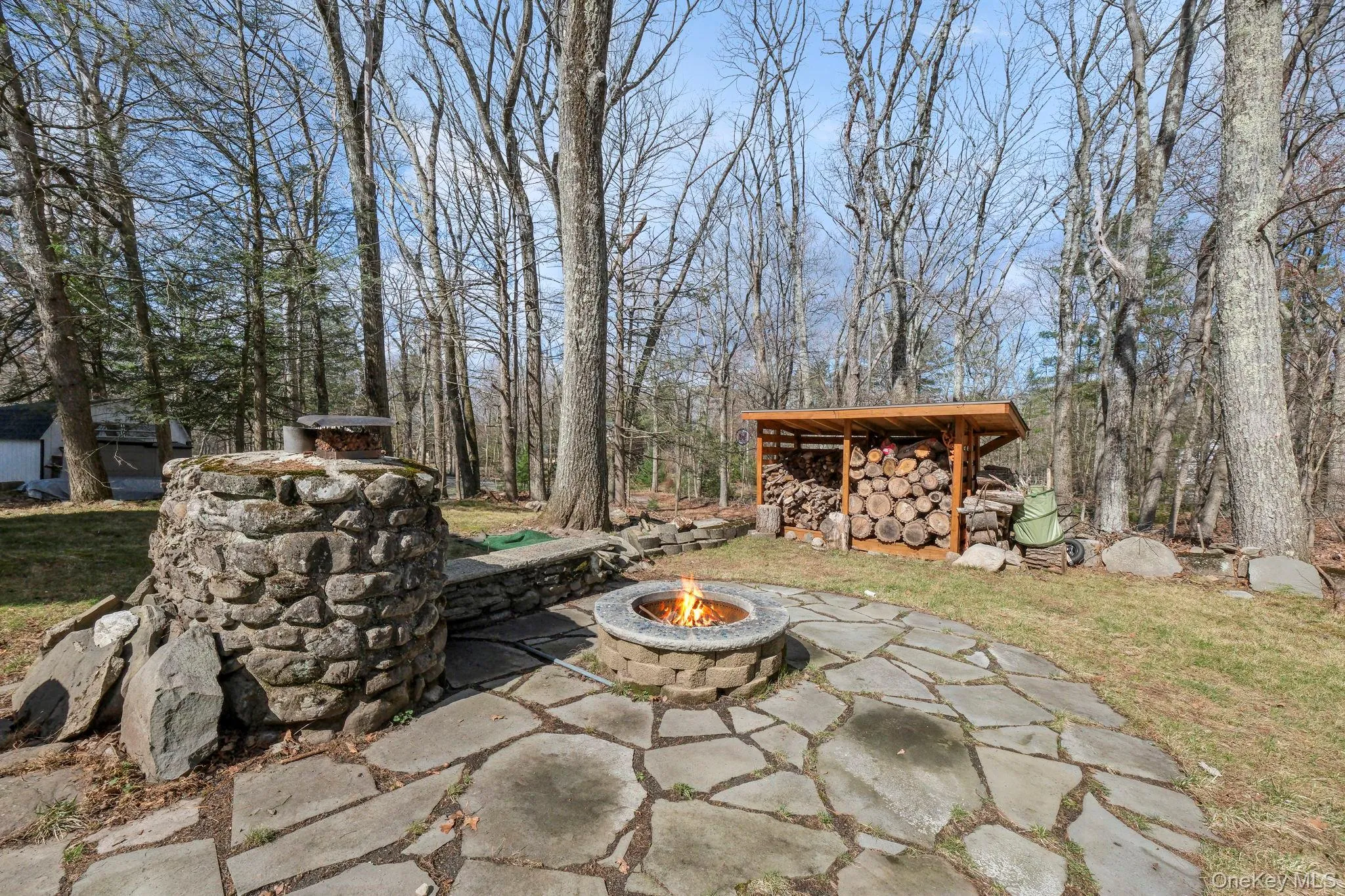 View of patio with a fire pit and an outbuilding View of patio with a fire pit and an outbuilding
