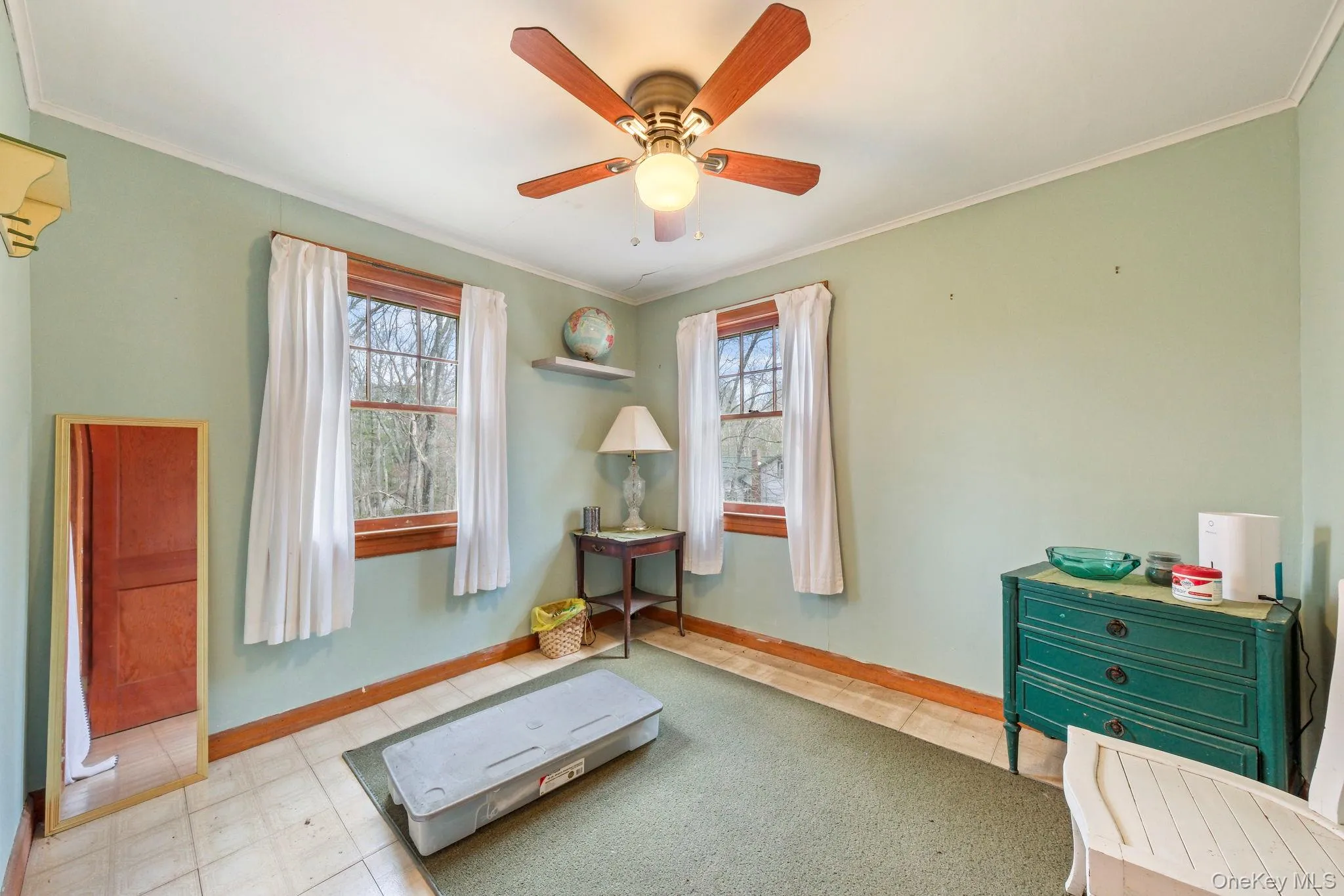 Exercise area or bedroom featuring light floors, ornamental molding, ceiling fan, and healthy amount of natural light Exercise area or bedroom featuring light floors, ornamental molding, ceiling fan, and healthy amount of natural light