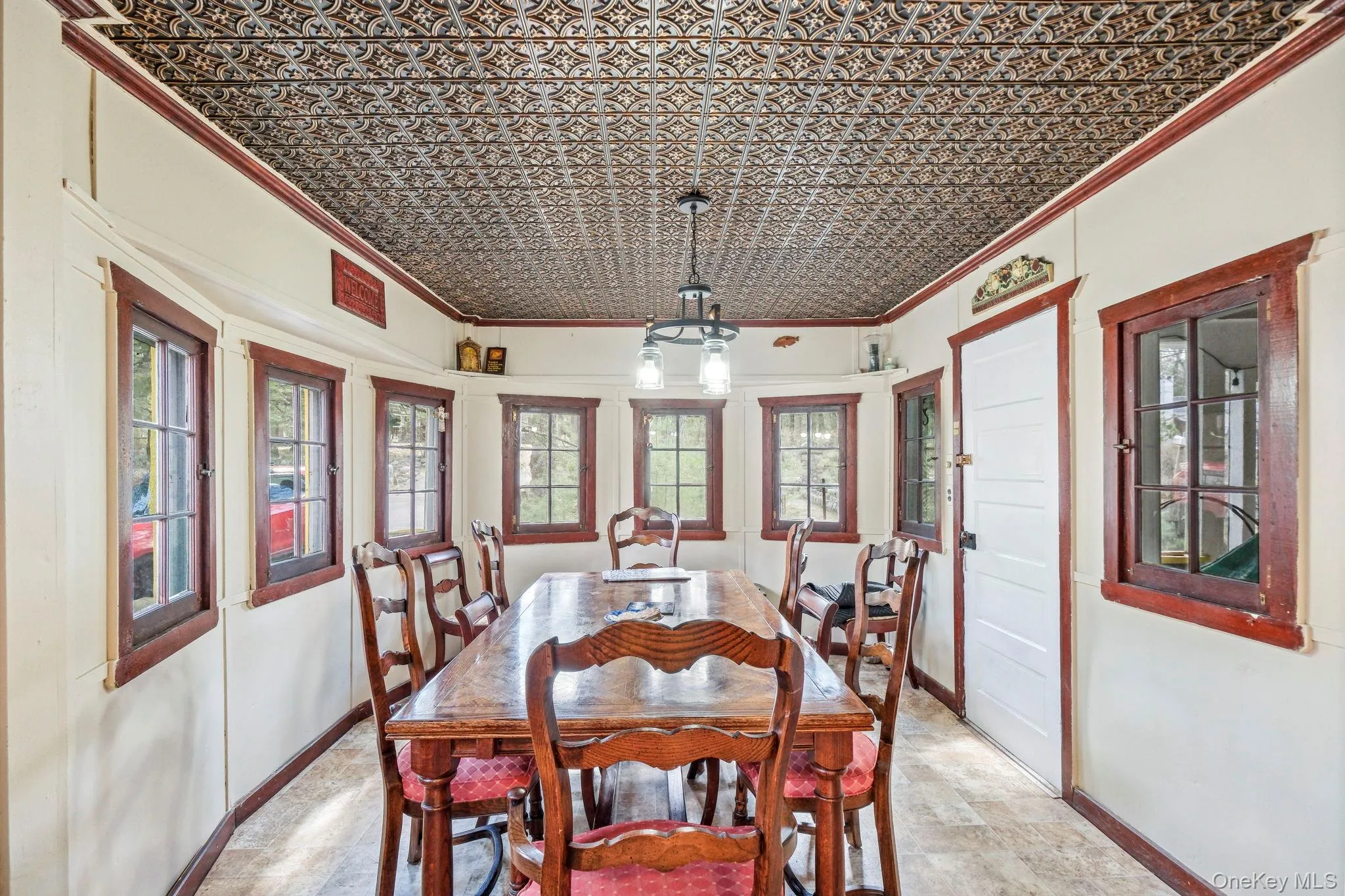 Dining area with crown molding, an ornate ceiling, unique rounded walls, and stone finish floors Dining area with crown molding, an ornate ceiling, unique rounded walls, and stone finish floors