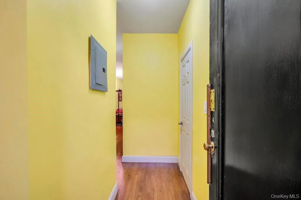 Hallway with electric panel and dark wood-style flooring Hallway with electric panel and dark wood-style flooring