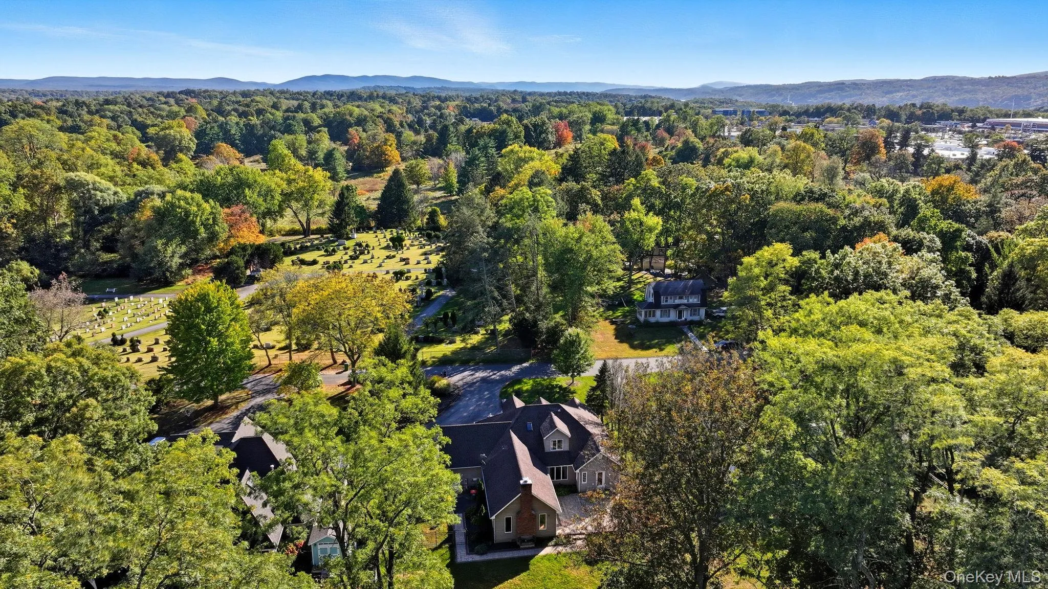 Drone / aerial view of a heavily wooded area and a mountain backdrop Drone / aerial view of a heavily wooded area and a mountain backdrop
