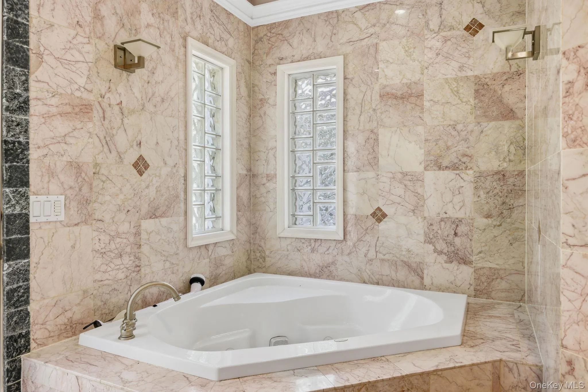 Bathroom featuring a bath, ornamental molding, and tile walls Bathroom featuring a bath, ornamental molding, and tile walls