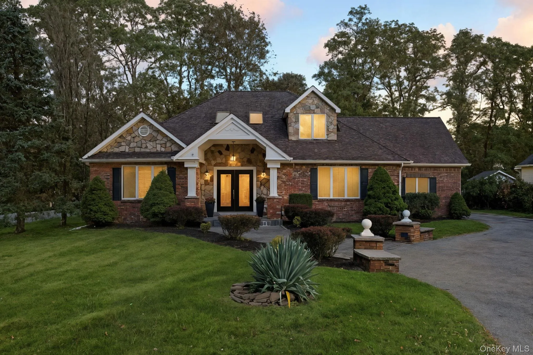 View of front of home featuring a lawn, brick siding, french doors, and stone siding View of front of home featuring a lawn, brick siding, french doors, and stone siding