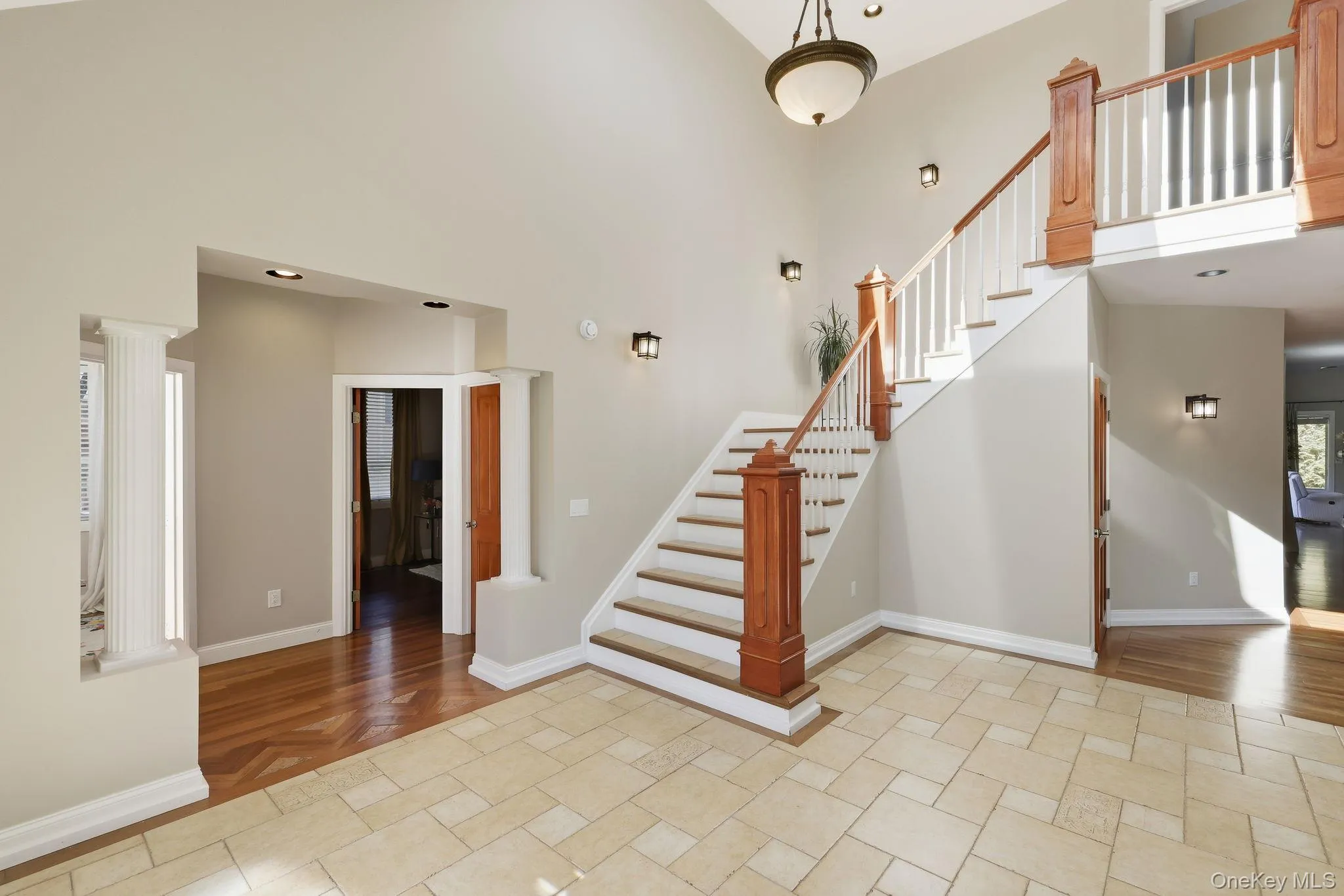 Stairs with a high ceiling, wood finished floors, and recessed lighting Stairs with a high ceiling, wood finished floors, and recessed lighting