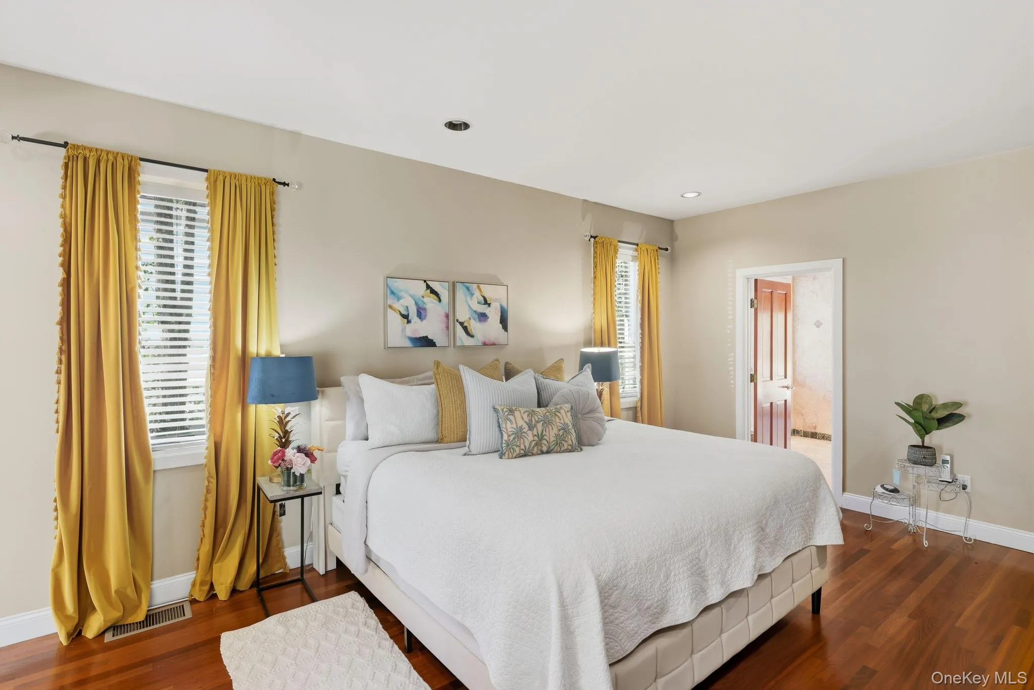 Bedroom featuring dark wood-style flooring, ensuite bath, and recessed lighting Bedroom featuring dark wood-style flooring, ensuite bath, and recessed lighting