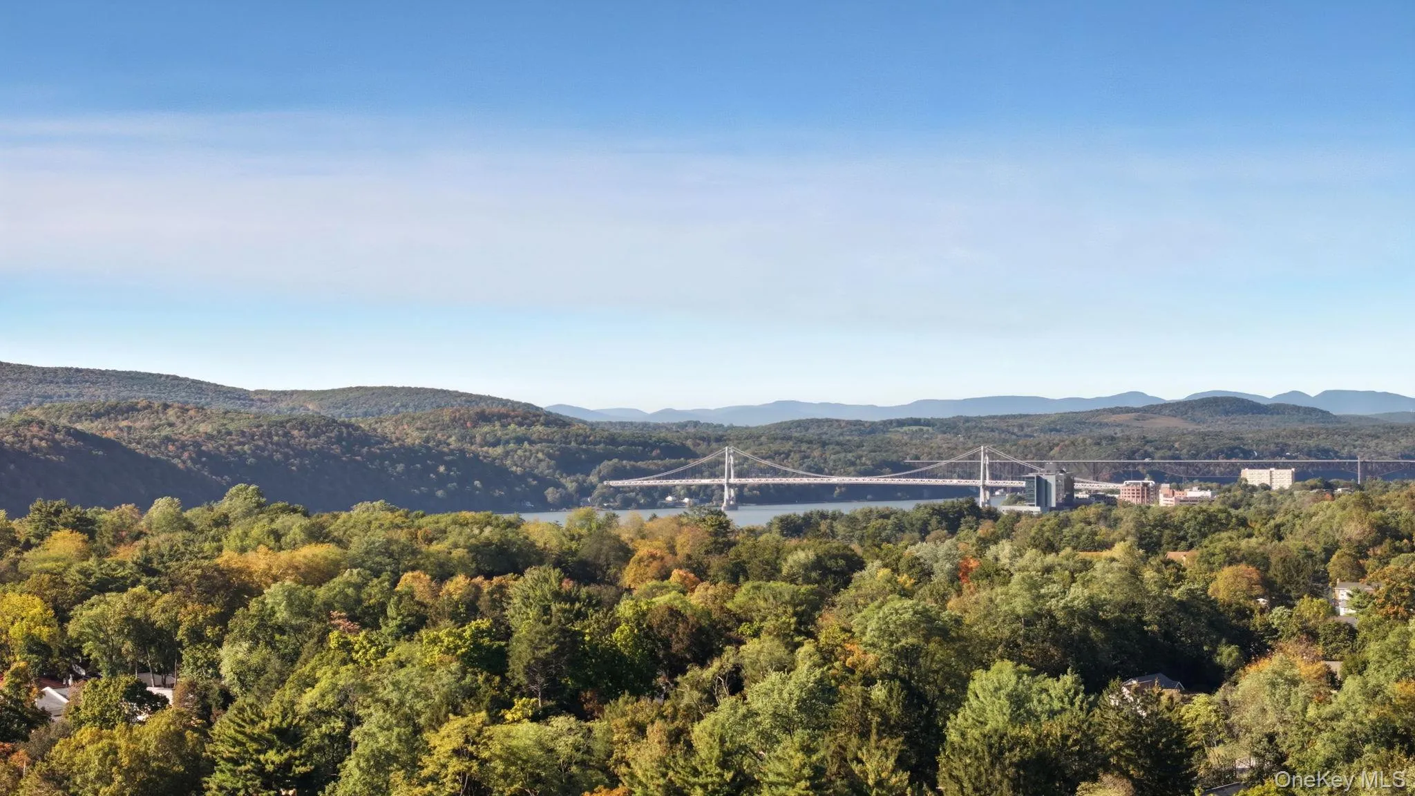 Mountain view featuring a notable bridge and a nearby body of water Mountain view featuring a notable bridge and a nearby body of water