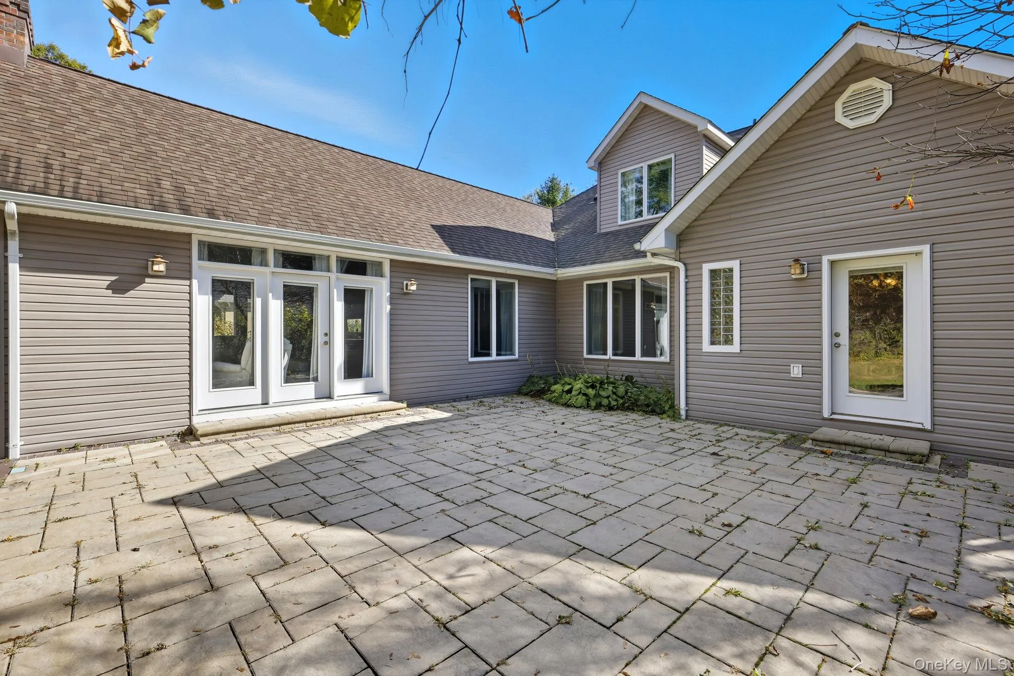 Rear view of property featuring a patio area and roof with shingles Rear view of property featuring a patio area and roof with shingles