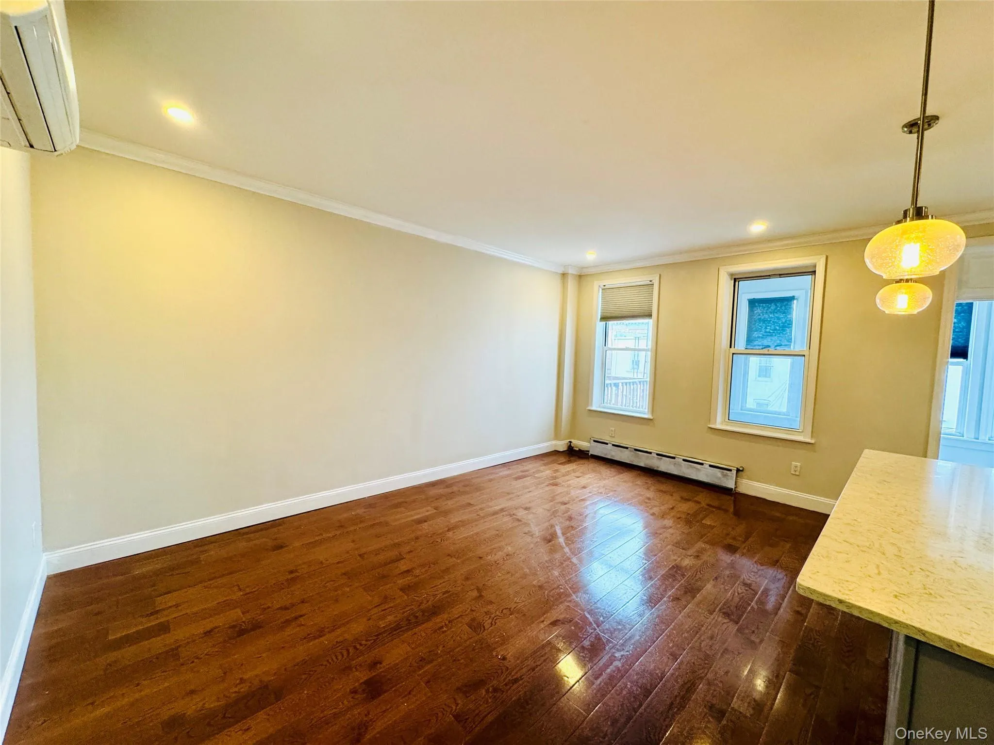 Unfurnished dining area featuring dark wood-style flooring, a wall mounted AC, a baseboard heating unit, crown molding, and recessed lighting Unfurnished dining area featuring dark wood-style flooring, a wall mounted AC, a baseboard heating unit, crown molding, and recessed lighting