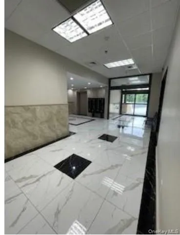 Lobby featuring a paneled ceiling and wainscoting Lobby featuring a paneled ceiling and wainscoting