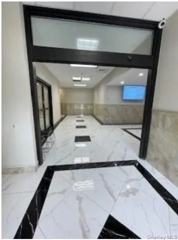 Hall featuring marble tiled flooring and inlaid floor details Hall featuring marble tiled flooring and inlaid floor details