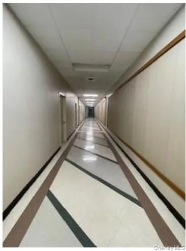 Hallway featuring a paneled ceiling and inlaid floor details Hallway featuring a paneled ceiling and inlaid floor details