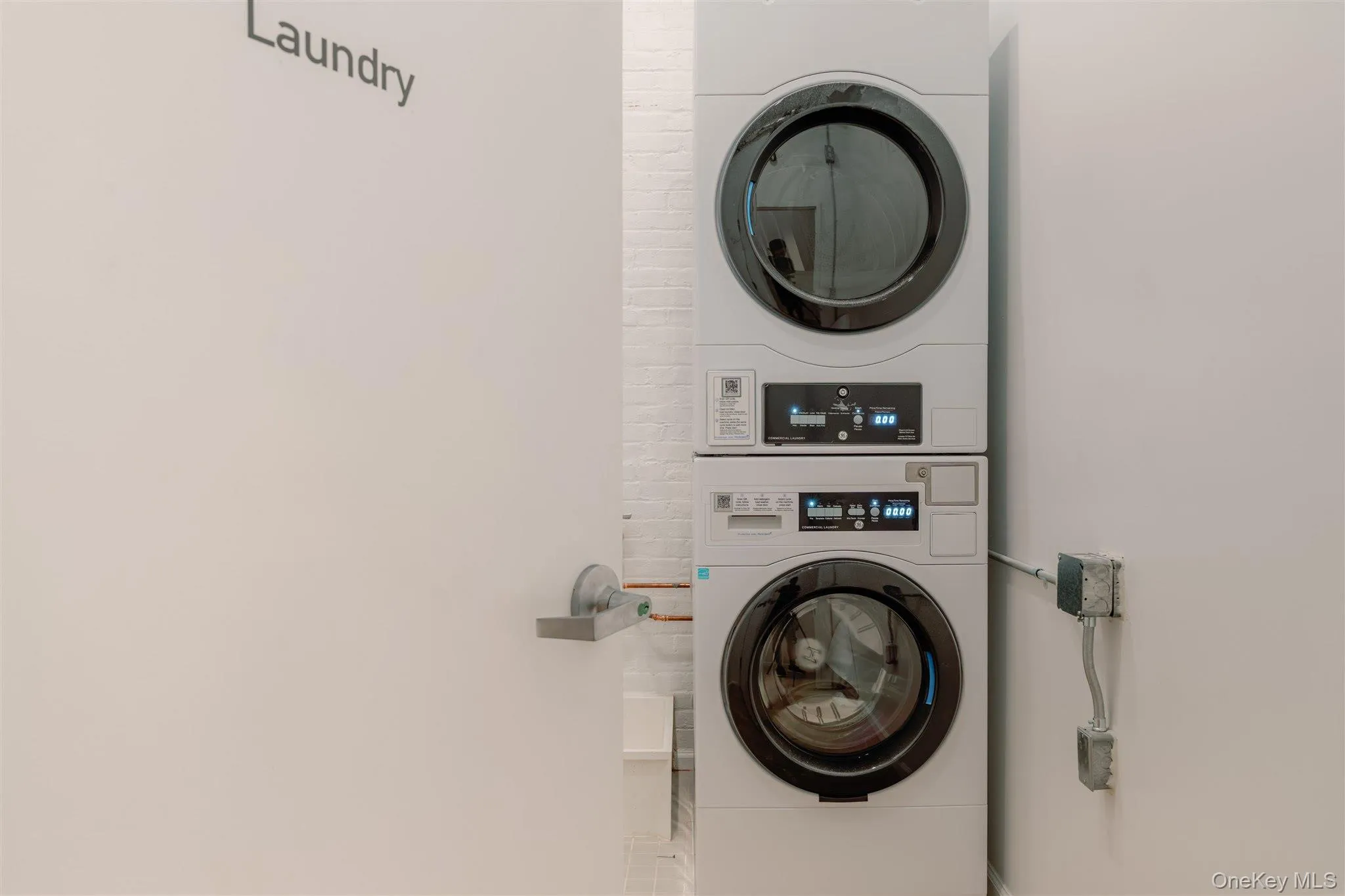 Laundry area featuring stacked washing machine and dryer Laundry area featuring stacked washing machine and dryer