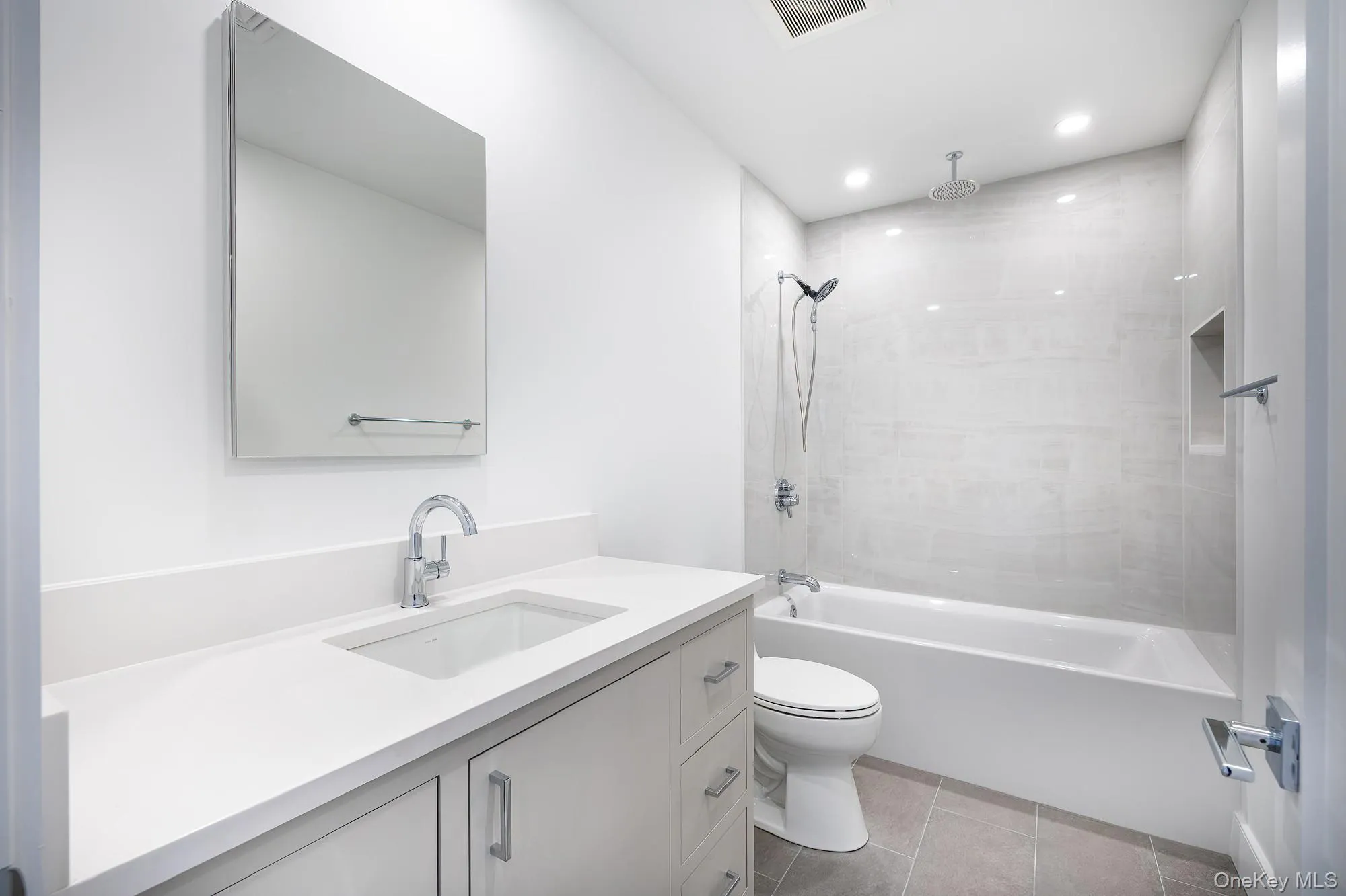 Bathroom featuring a combined bath / shower with rainfall shower, vanity, light tile patterned floors, and recessed lighting Bathroom featuring a combined bath / shower with rainfall shower, vanity, light tile patterned floors, and recessed lighting