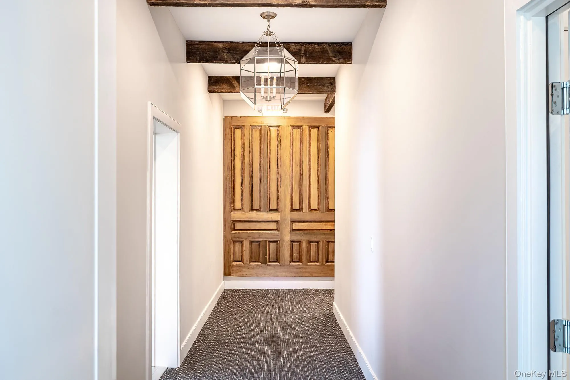 Corridor with beamed ceiling and dark carpet Corridor with beamed ceiling and dark carpet