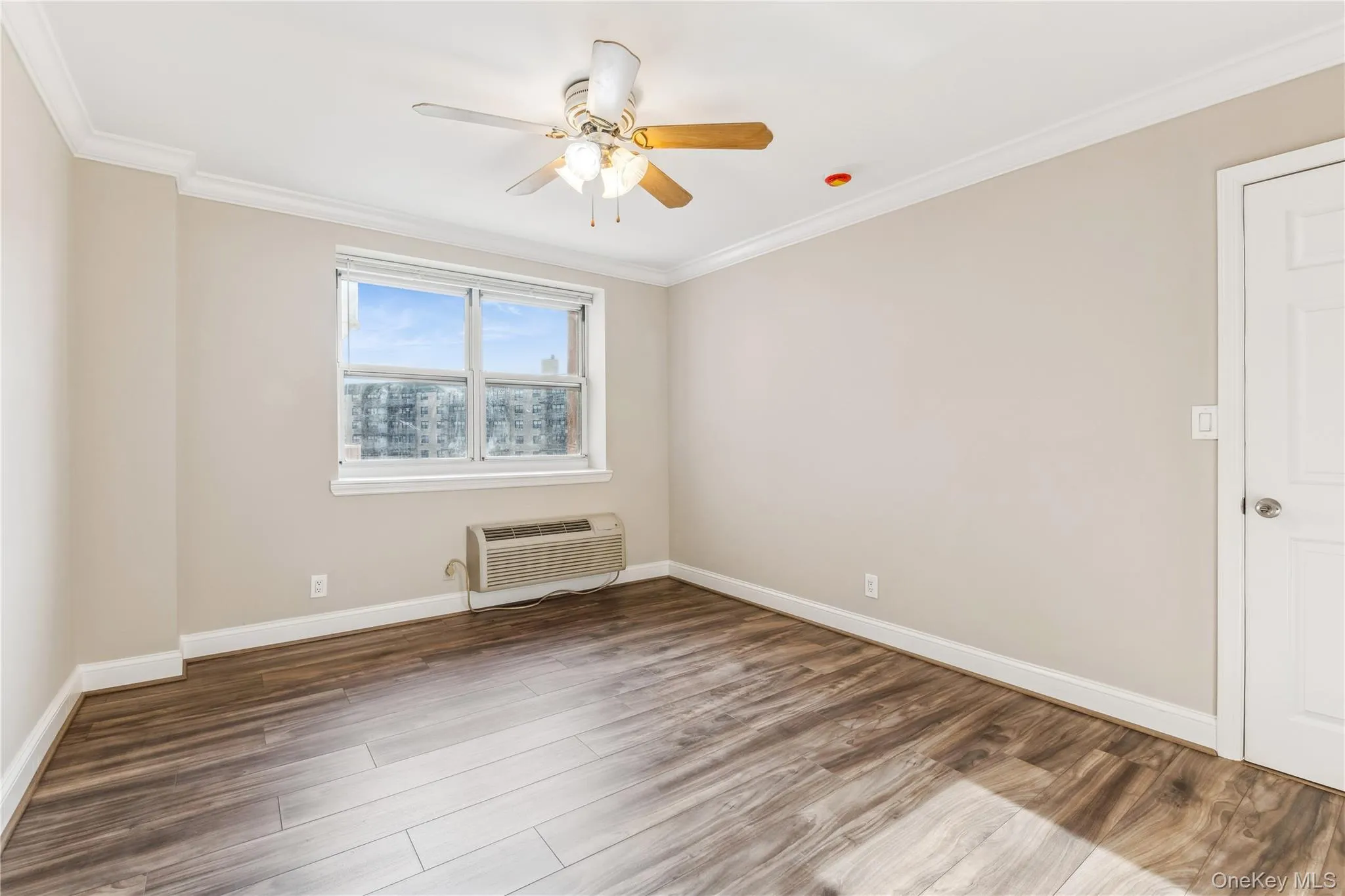 Unfurnished room with a wall mounted air conditioner, dark hardwood / wood-style floors, ceiling fan, and crown molding Unfurnished room with a wall mounted air conditioner, dark hardwood / wood-style floors, ceiling fan, and crown molding