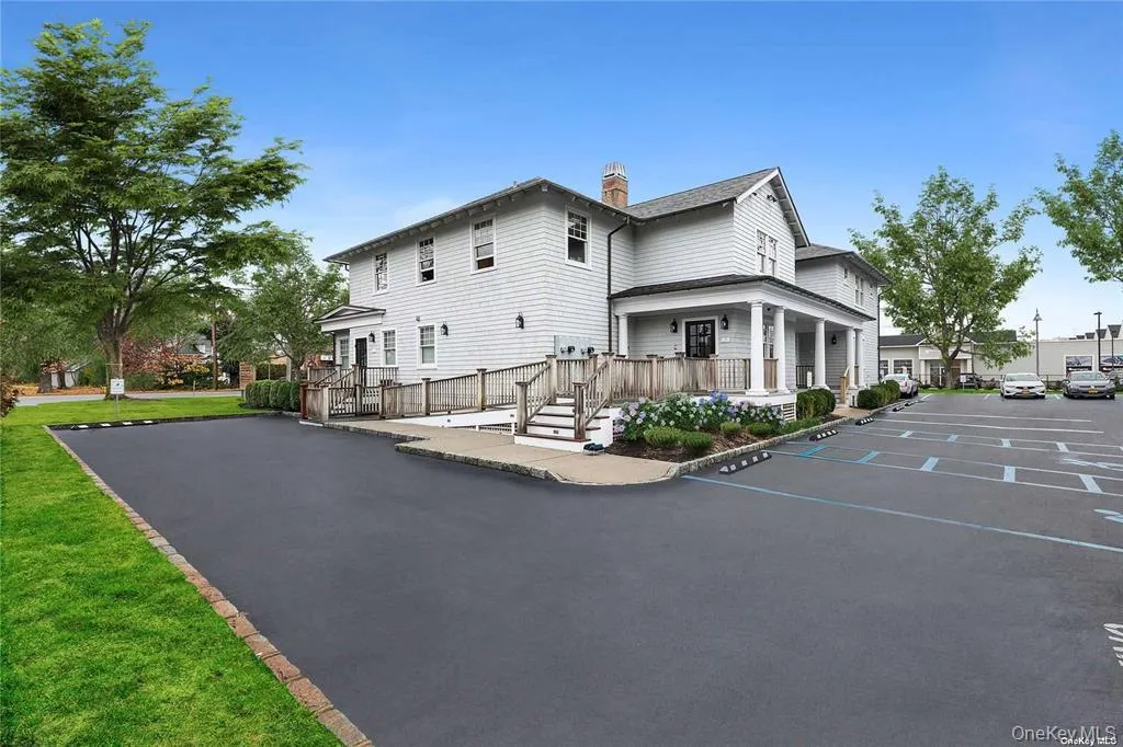 View of home's exterior featuring a chimney, covered porch, a lawn, and uncovered parking View of home's exterior featuring a chimney, covered porch, a lawn, and uncovered parking