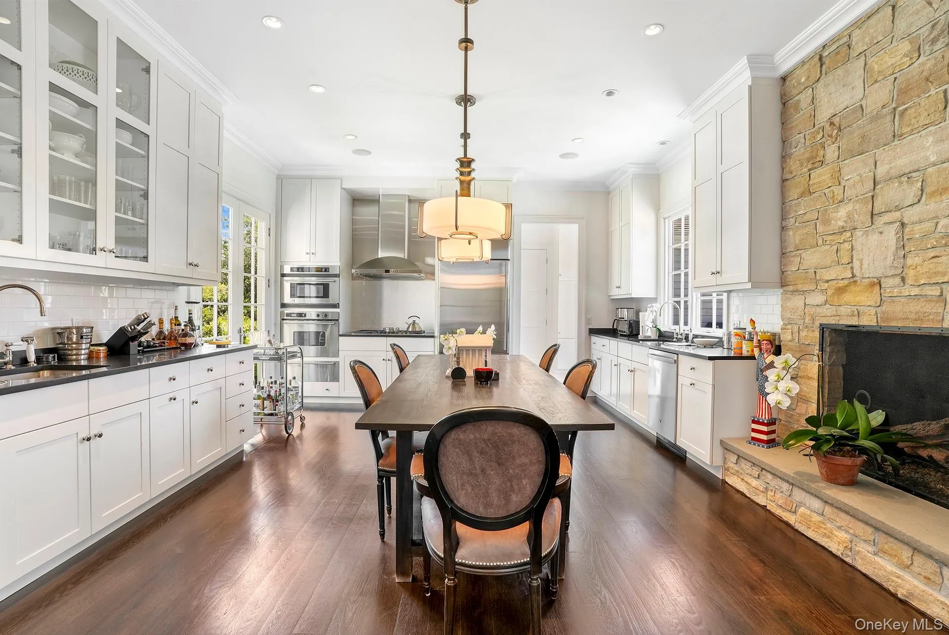 Dining space with crown molding, dark wood-style floors, a fireplace, and recessed lighting Dining space with crown molding, dark wood-style floors, a fireplace, and recessed lighting