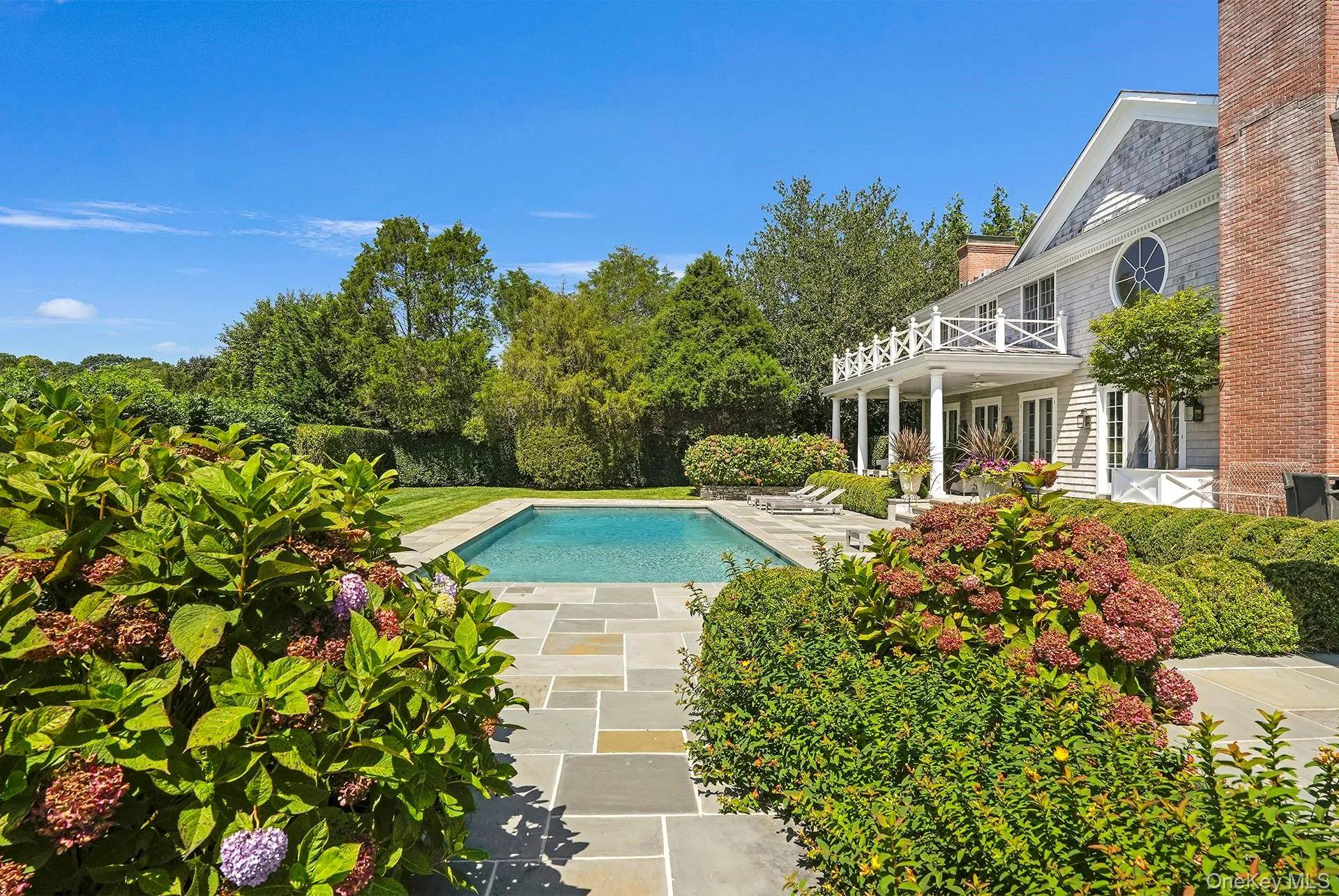 View of swimming pool featuring a patio, a balcony, and view of wooded area View of swimming pool featuring a patio, a balcony, and view of wooded area