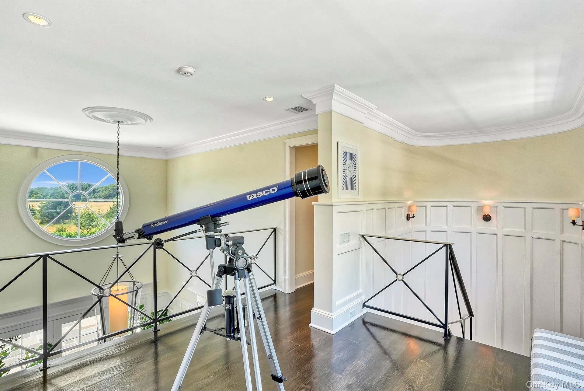 Hall with dark wood-style flooring, crown molding, recessed lighting, a decorative wall, and a wainscoted wall Hall with dark wood-style flooring, crown molding, recessed lighting, a decorative wall, and a wainscoted wall