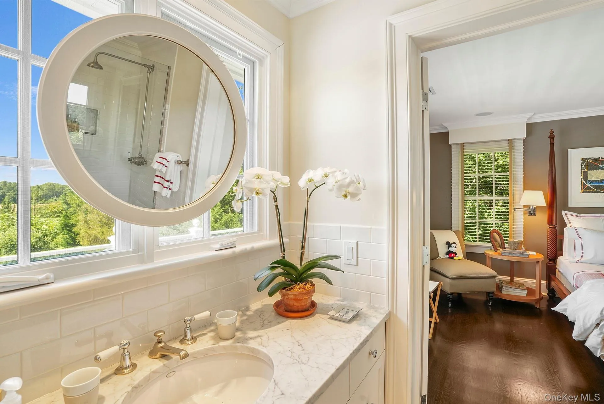 Ensuite bathroom featuring crown molding, vanity, and dark wood finished floors Ensuite bathroom featuring crown molding, vanity, and dark wood finished floors