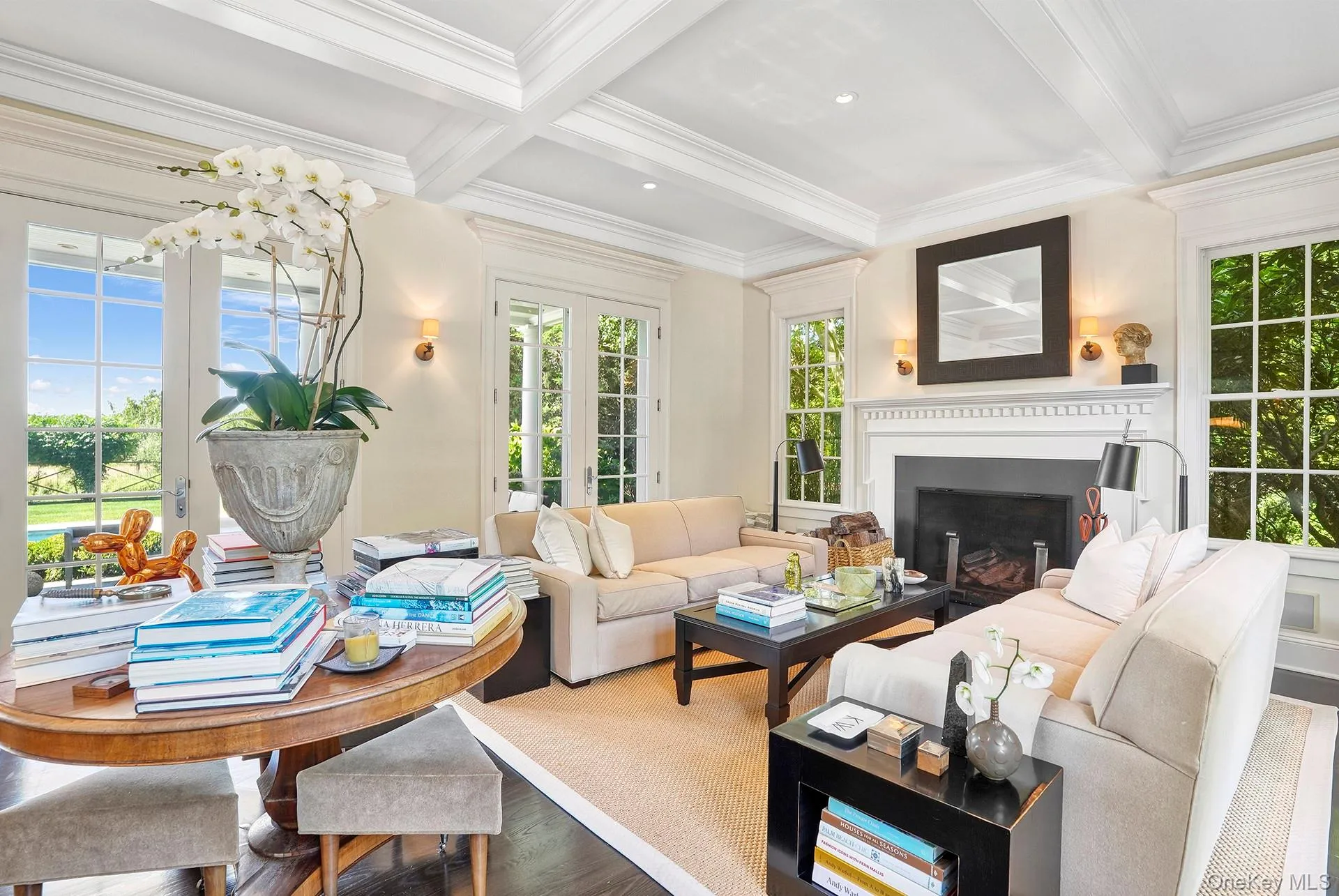 Living room with beamed ceiling, plenty of natural light, coffered ceiling, ornamental molding, and a fireplace Living room with beamed ceiling, plenty of natural light, coffered ceiling, ornamental molding, and a fireplace