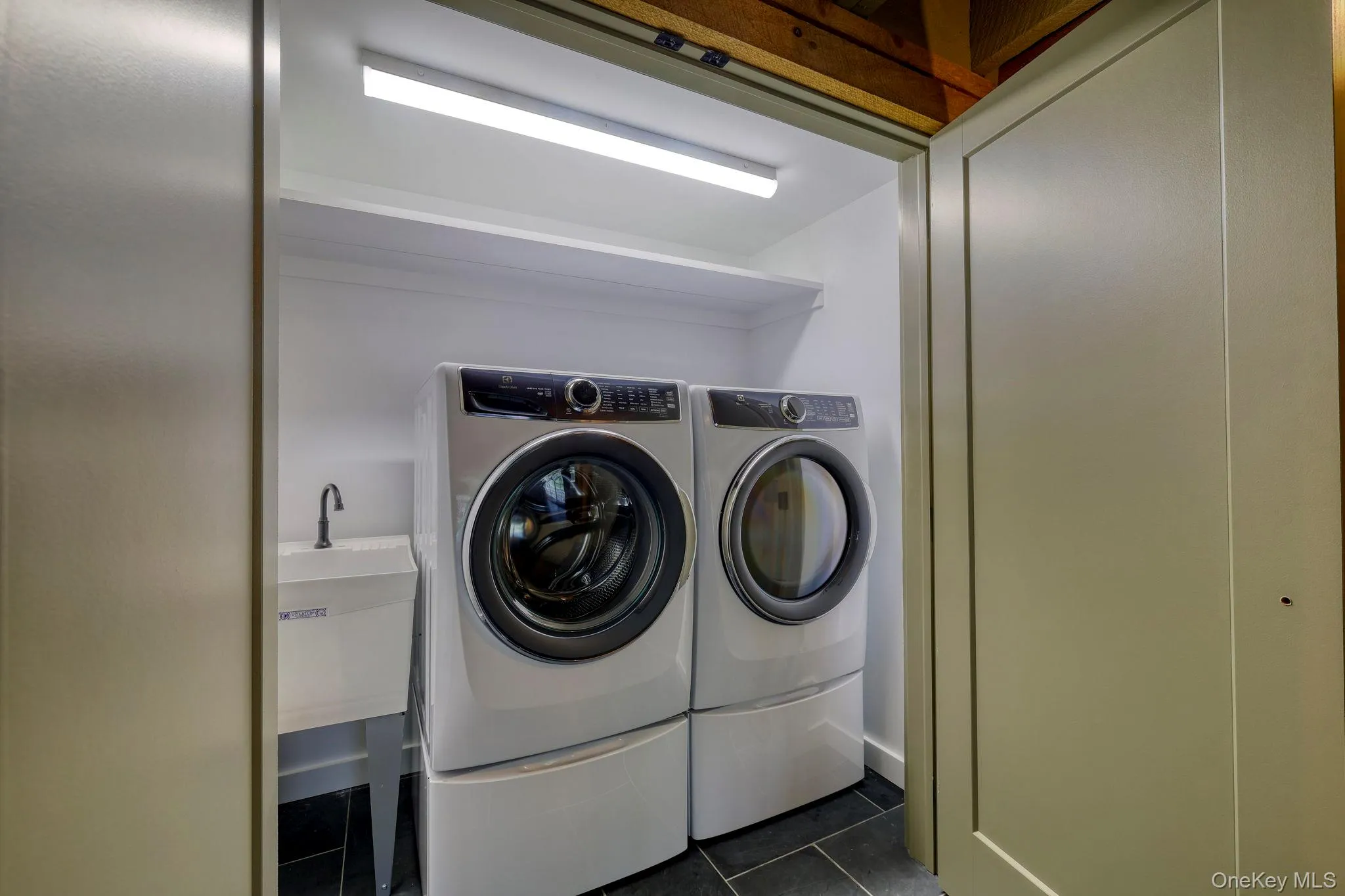 Laundry room featuring dark tile patterned floors and separate washer and dryer Laundry room featuring dark tile patterned floors and separate washer and dryer