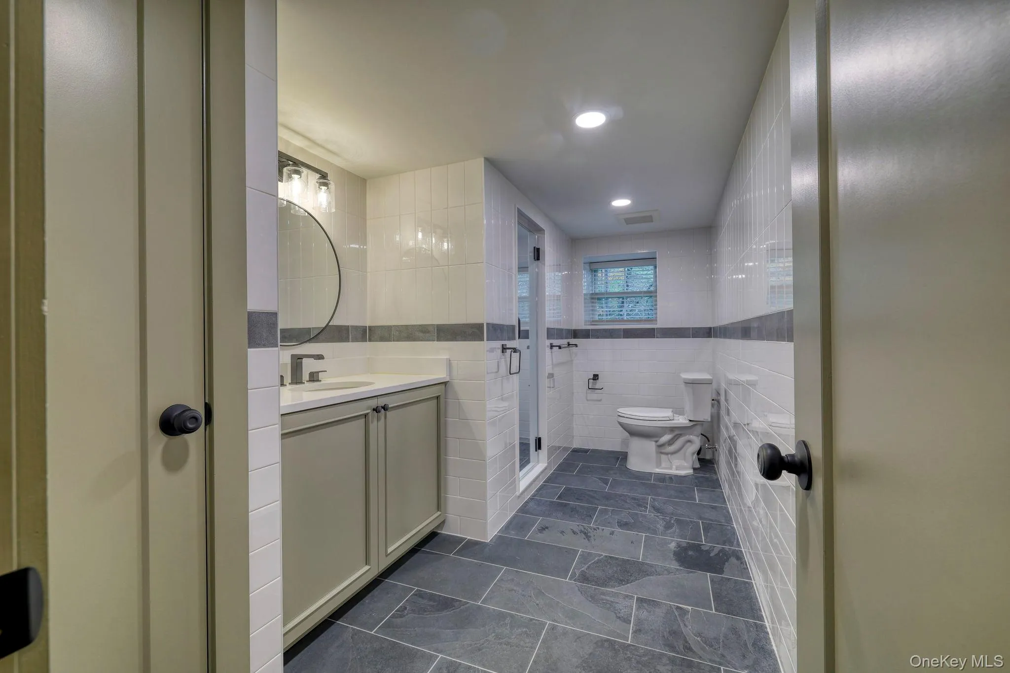 Full bath with tile walls, vanity, a stall shower, and recessed lighting Full bath with tile walls, vanity, a stall shower, and recessed lighting