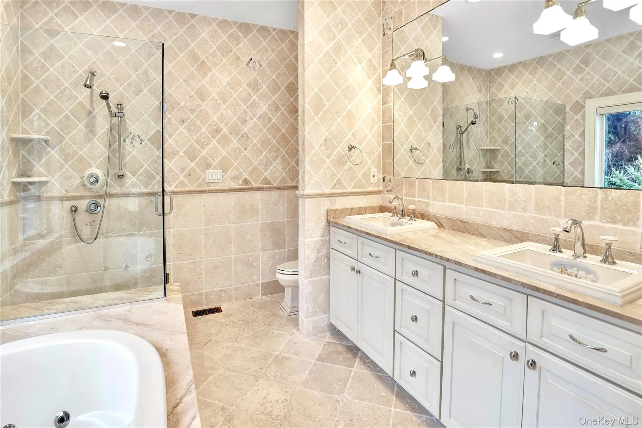 Full bathroom featuring tile walls, double vanity, a bathtub, a stall shower, and light tile patterned floors