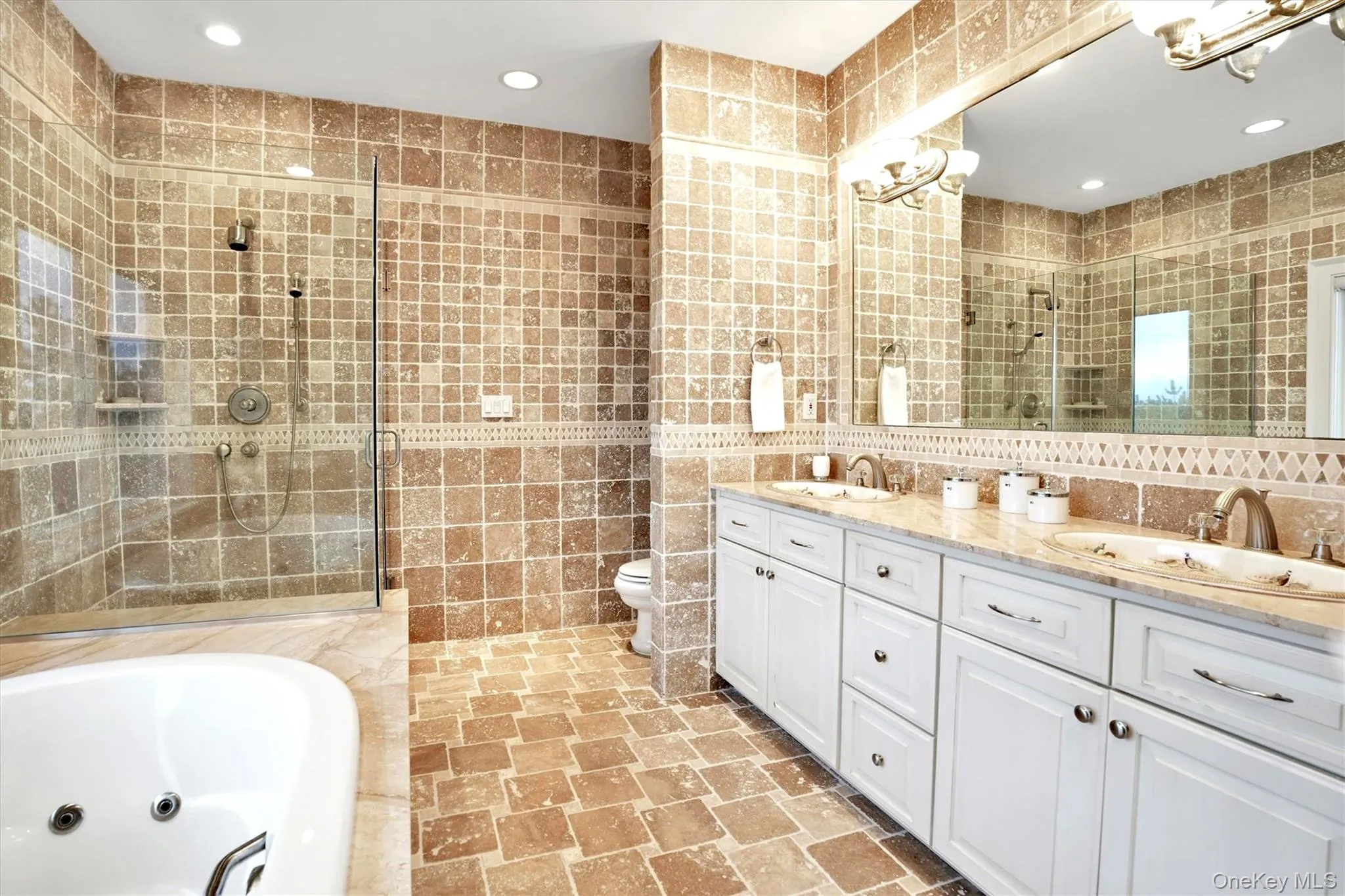 Second Floor Primary Bathroom en-suite featuring tile walls, double vanity, recessed lighting, a whirlpool tub, and a tile shower
