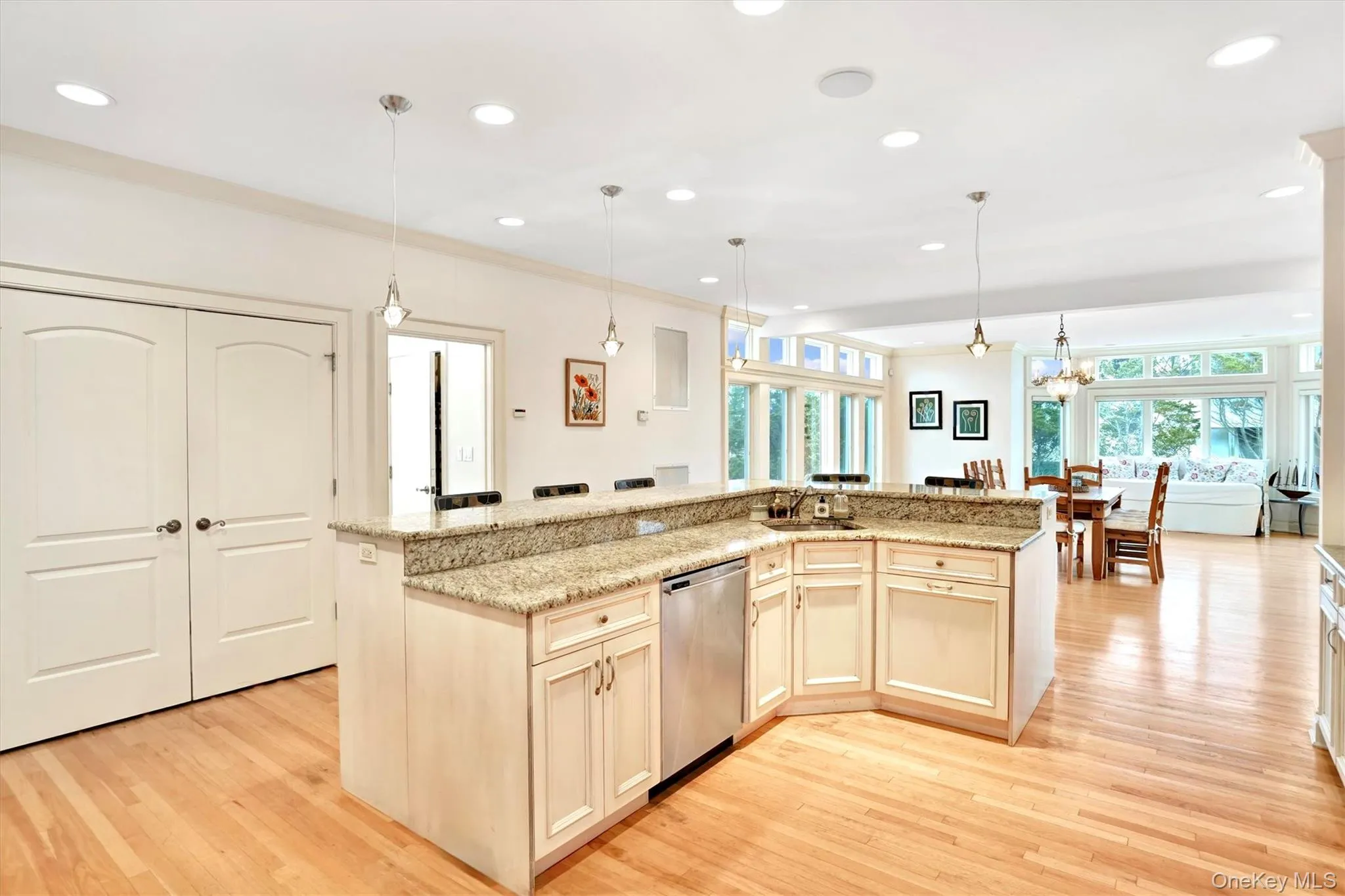 Kitchen island with recessed lighting, decorative light fixtures, light wood-style flooring, a center island with sink, and stainless steel Bosch dishwasher