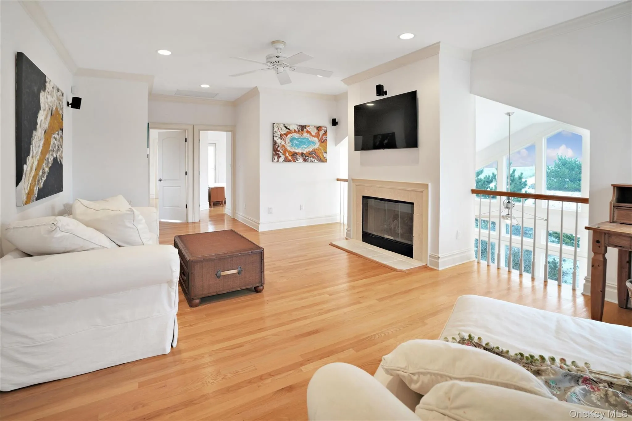 Second Floor Living area with ornamental molding, recessed lighting, light wood-style floors, a ceiling fan, and a glass covered fireplace. Gorgeous Views of Ocean