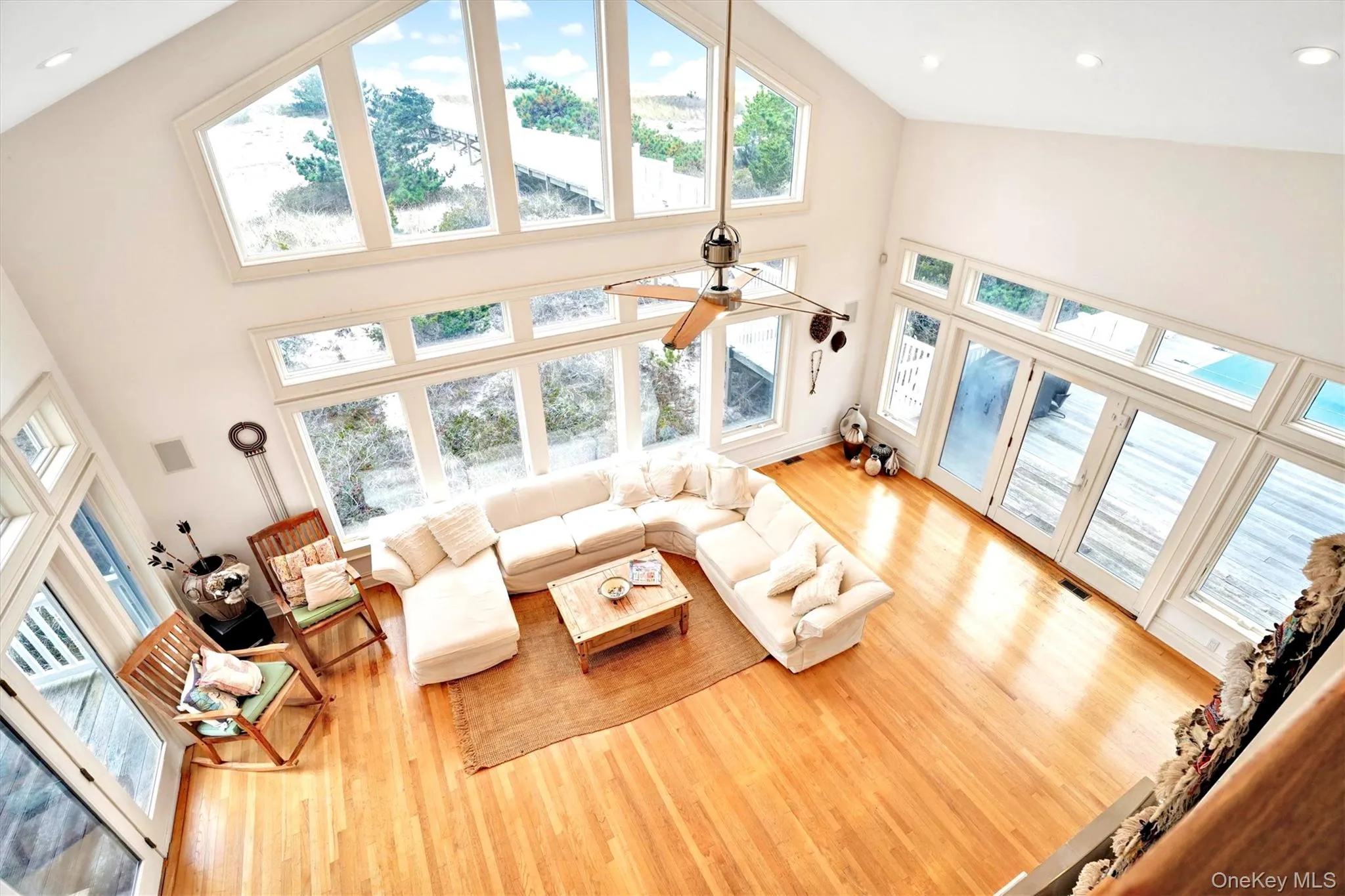 View from Second Floor family room overlooking the Living area featuring wood finished floors, a towering ceiling, and recessed lighting