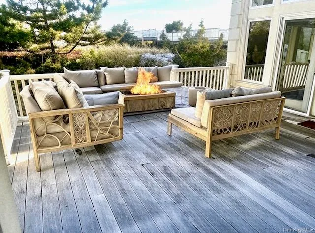 Ai Added furniture. Wooden terrace with an outdoor living space with a fire pit