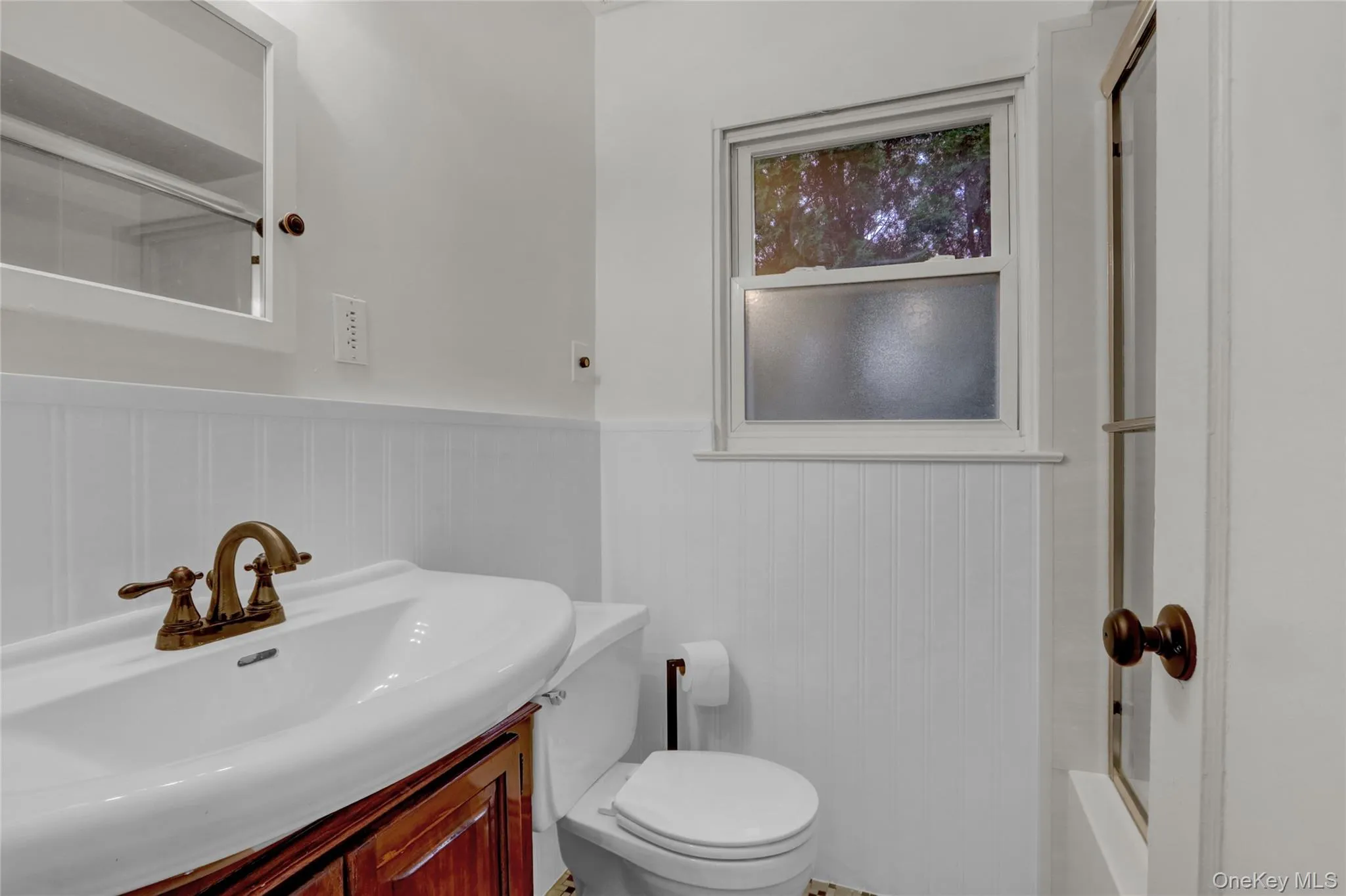 Full bath featuring vanity, a wainscoted wall, and tub / shower combination Full bath featuring vanity, a wainscoted wall, and tub / shower combination