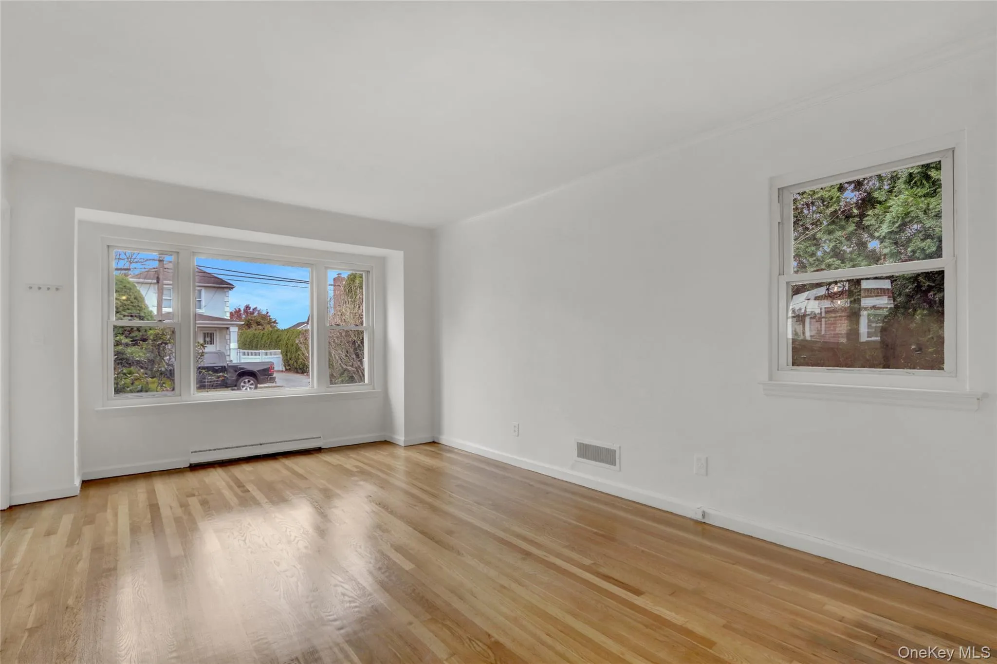 Living room with healthy amount of natural light, light wood-type flooring Living room with healthy amount of natural light, light wood-type flooring