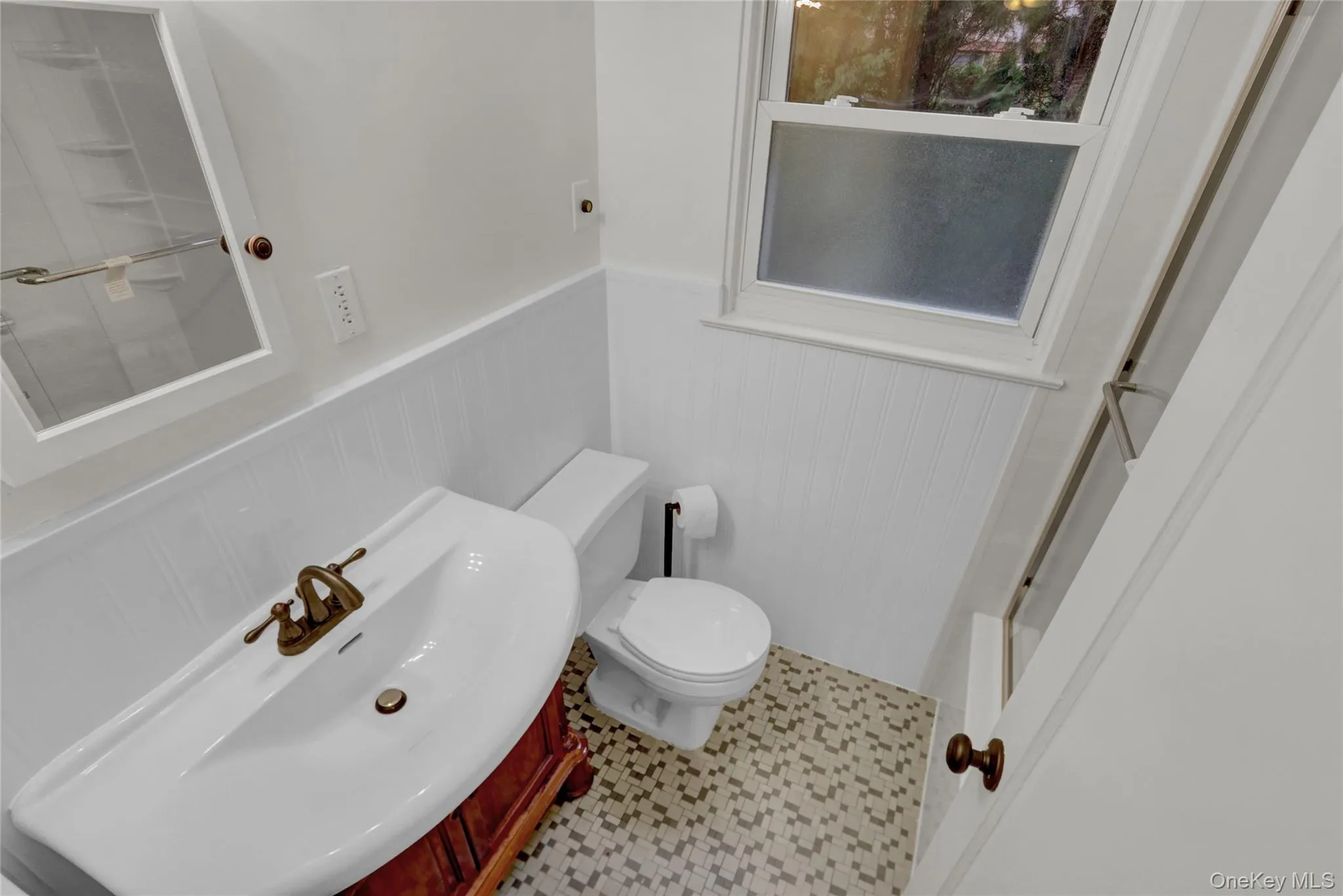 Full bathroom featuring wainscoting and vanity Full bathroom featuring wainscoting and vanity