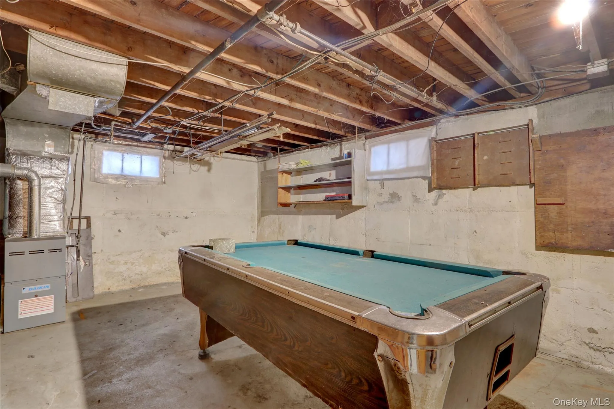 Rec room with billiards, unfinished concrete flooring, and heating unit Rec room with billiards, unfinished concrete flooring, and heating unit