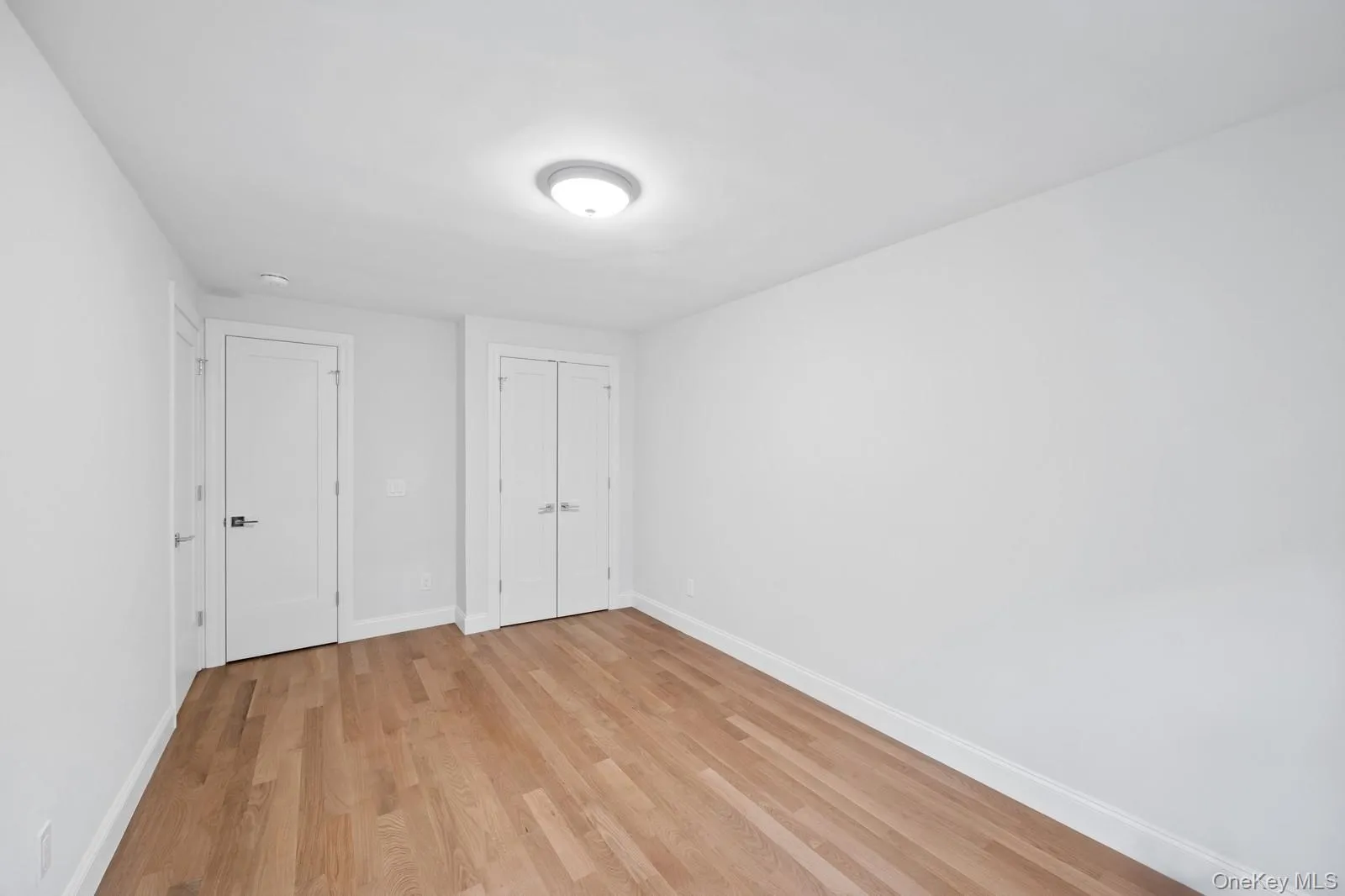 Unfurnished bedroom with light wood finished floors and a closet Unfurnished bedroom with light wood finished floors and a closet