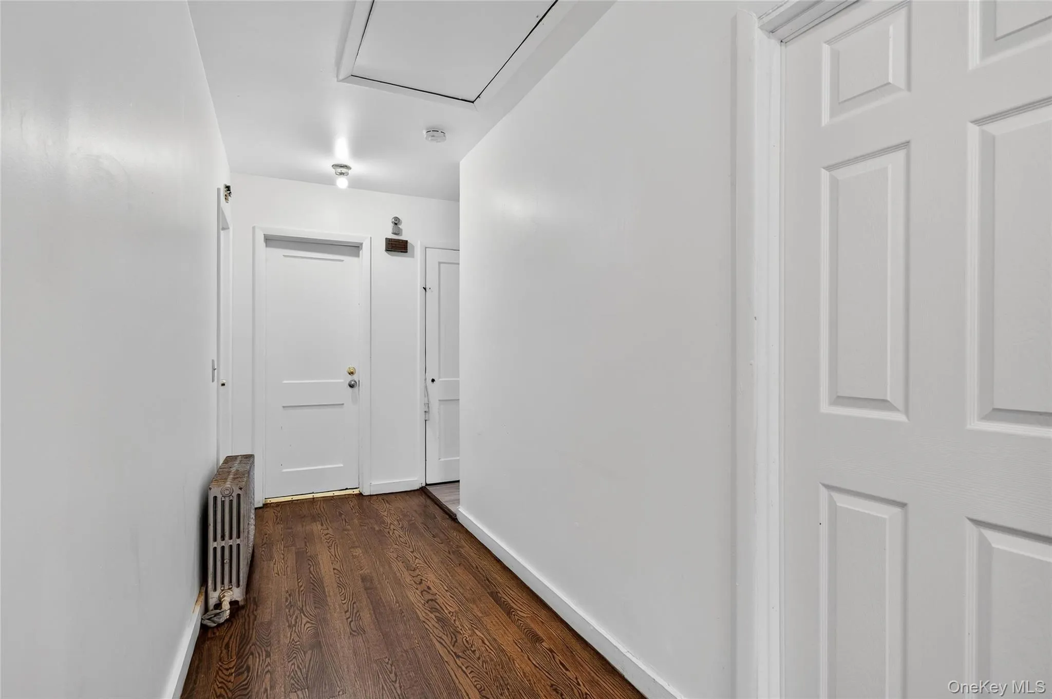 Hall featuring dark wood-type flooring and radiator heating unit Hall featuring dark wood-type flooring and radiator heating unit