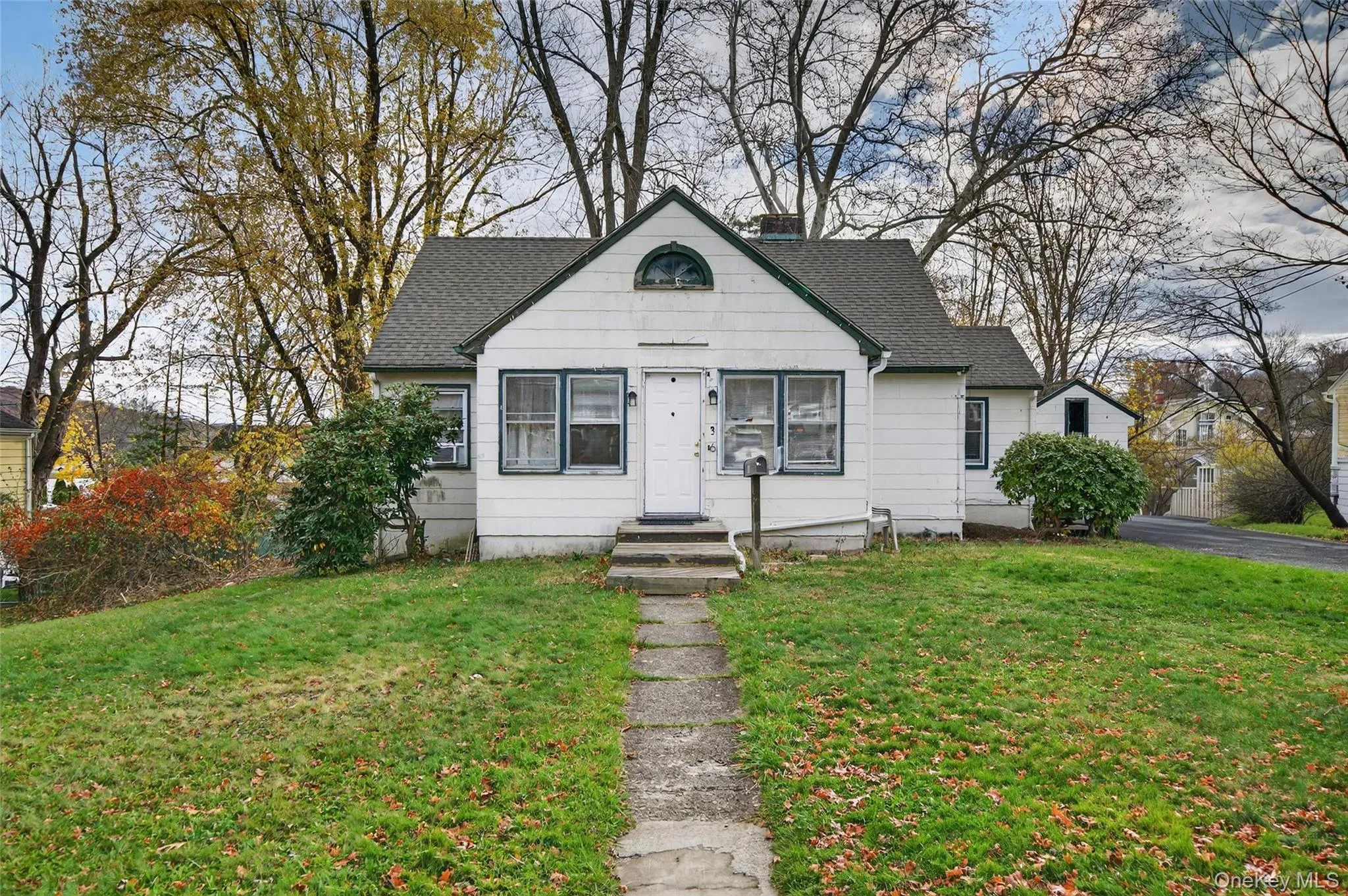 Bungalow-style home featuring a shingled roof, a front lawn, and a chimney Bungalow-style home featuring a shingled roof, a front lawn, and a chimney