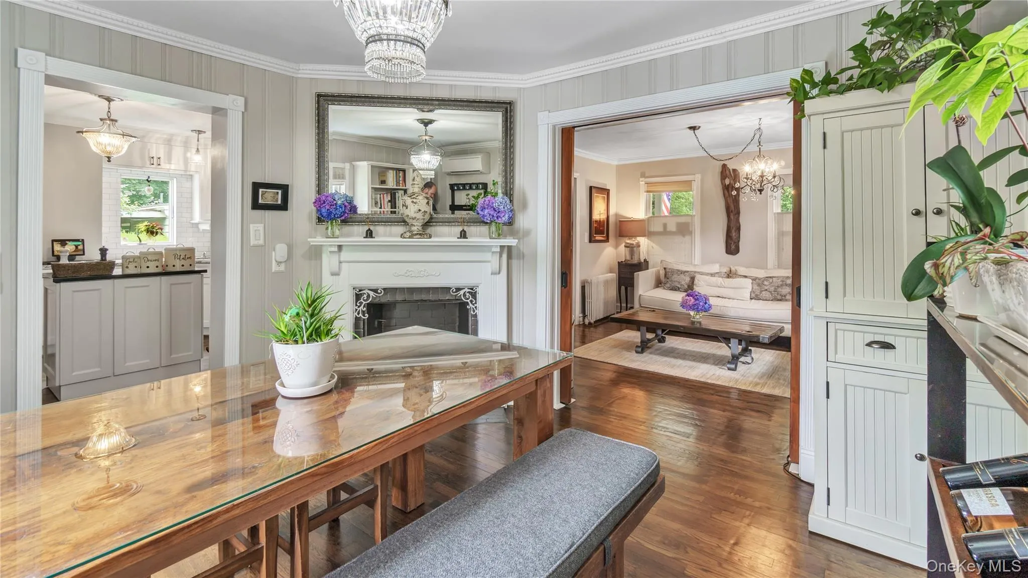 Dining space featuring a chandelier, a fireplace, crown molding, dark wood finished floors, and radiator Dining space featuring a chandelier, a fireplace, crown molding, dark wood finished floors, and radiator