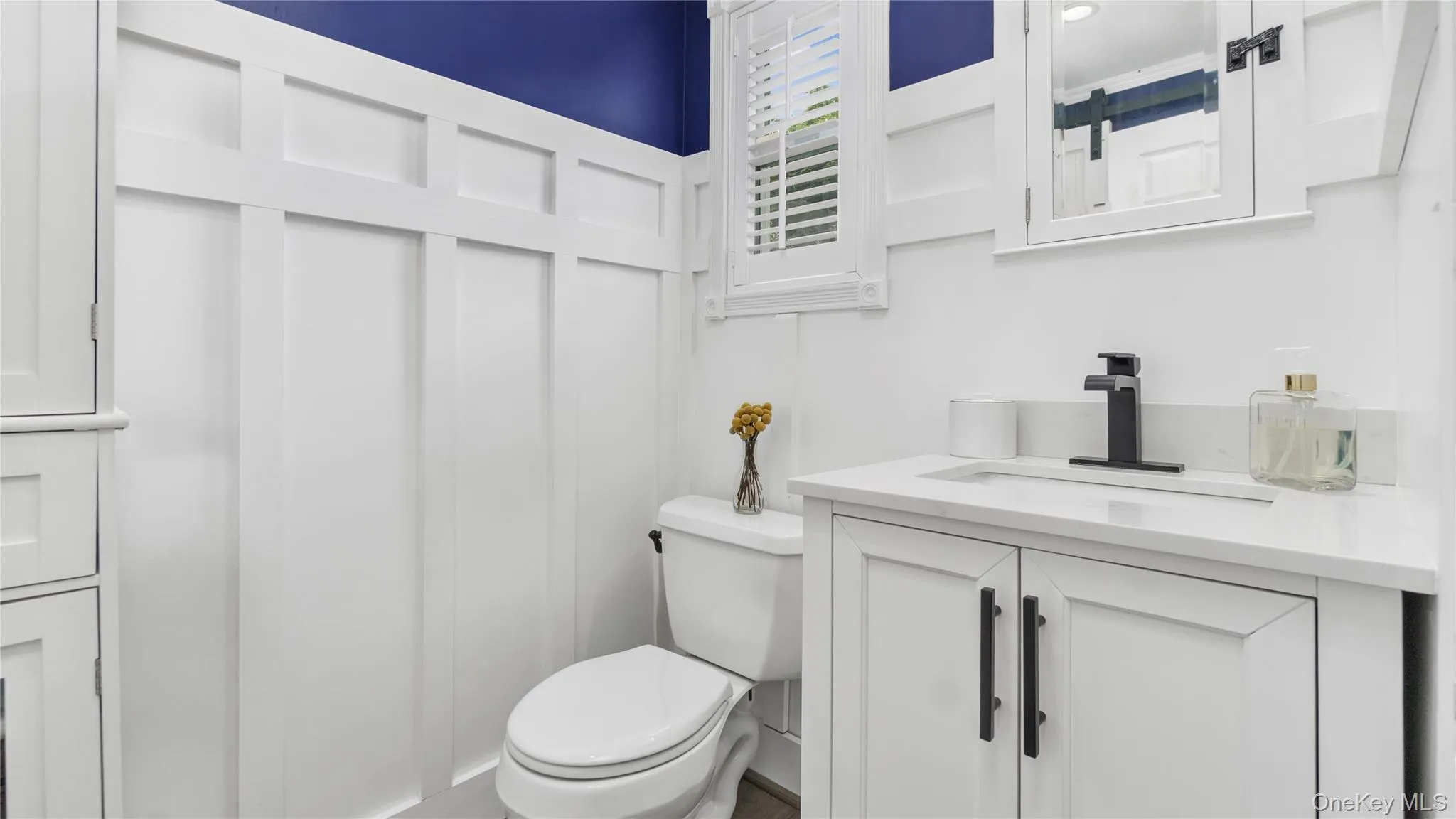 Half bathroom featuring vanity and toilet Half bathroom featuring vanity and toilet